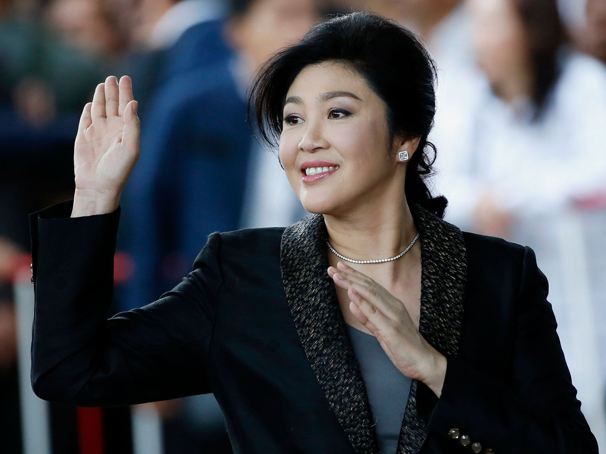 Yingluck Shinawatra waves to supporters as she arrives to deliver closing statements in her trial on 1 August - but has apparently fled before hearing the verdict