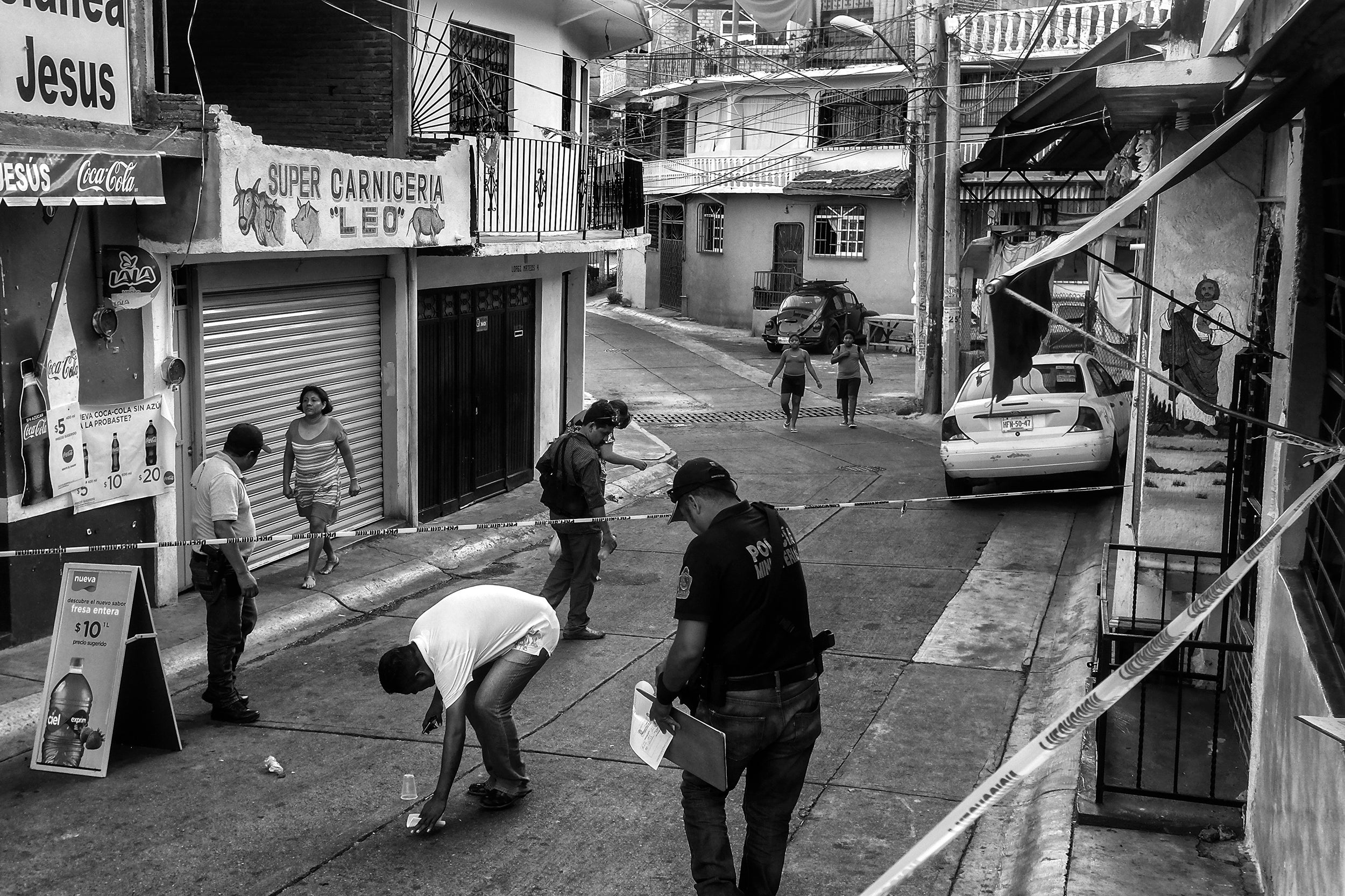 Police look for spent shell casings at the scene of a murder in the Colonia Santa Cruz neighbourhood