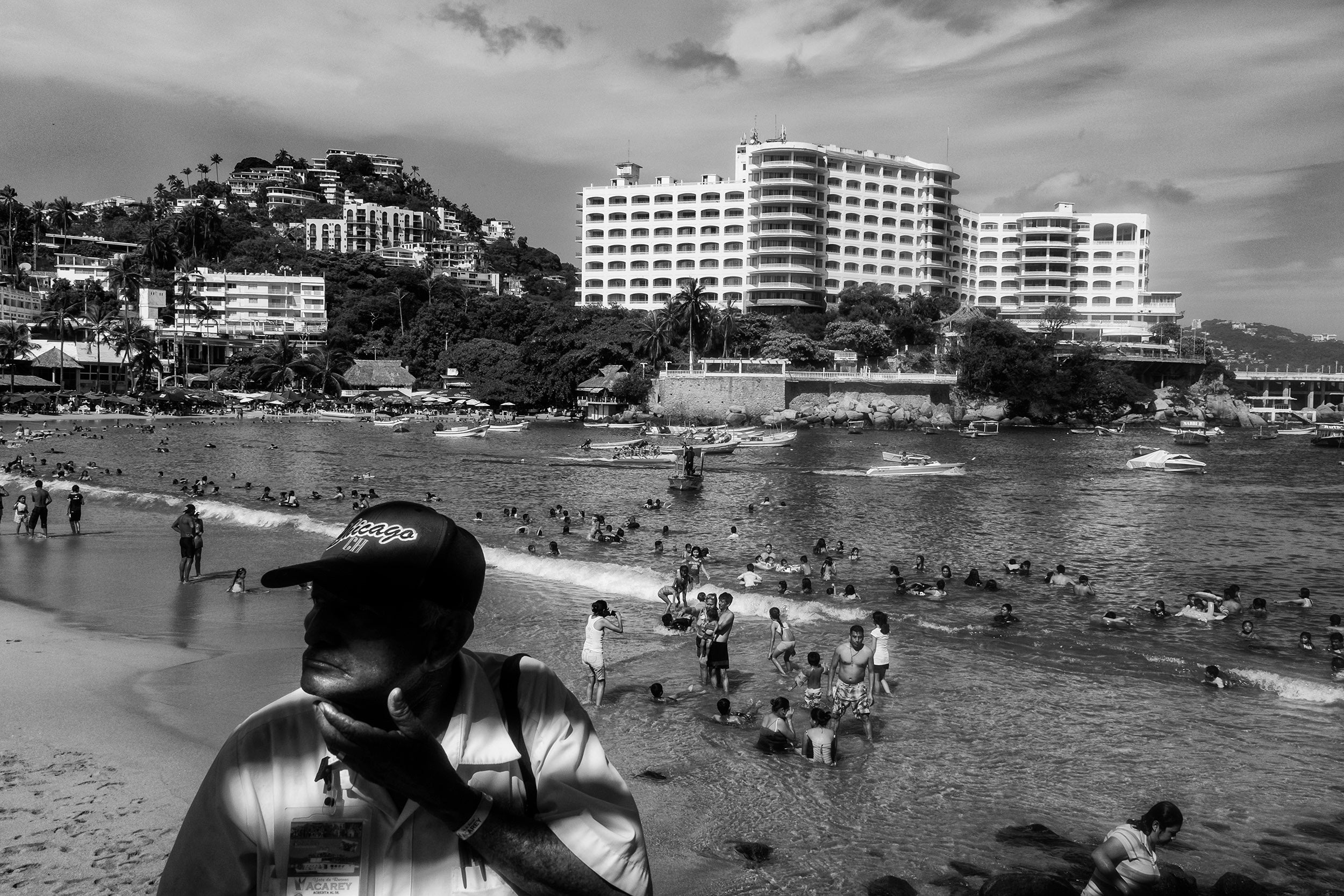 Residents and tourists play in the Pacific Ocean at La Caleta, a popular Acapulco beach. Hotel vacancies are higher, and many establishments are in a state of disrepair