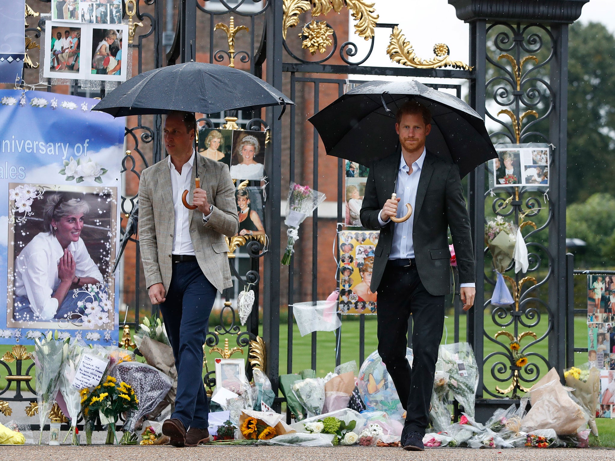 Prince William and Prince Harry place flowers at the gates of Kensington Palace