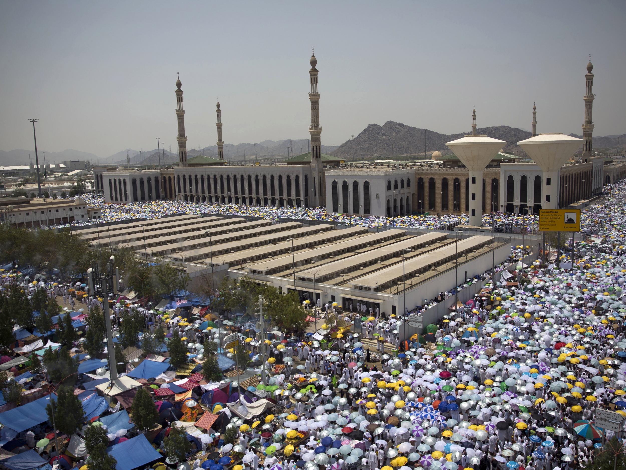 Muslim pilgrims hold umbrellas as they attend noon prayers outside the Namirah mosque on Arafat Mountain during the annual Hajj pilgrimage outside the holy city of Mecca, Saudi Arabia