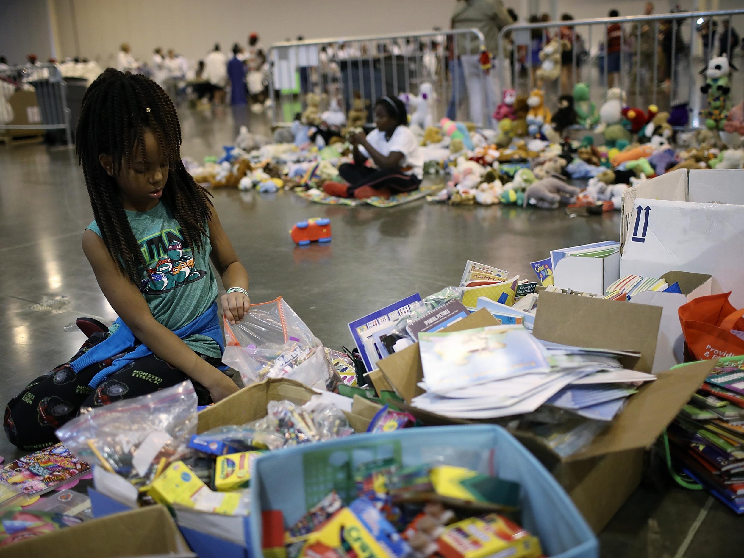 Children from families forced from their homes due to flooding play with donated toys at Houston’s NRG Centre (Getty)