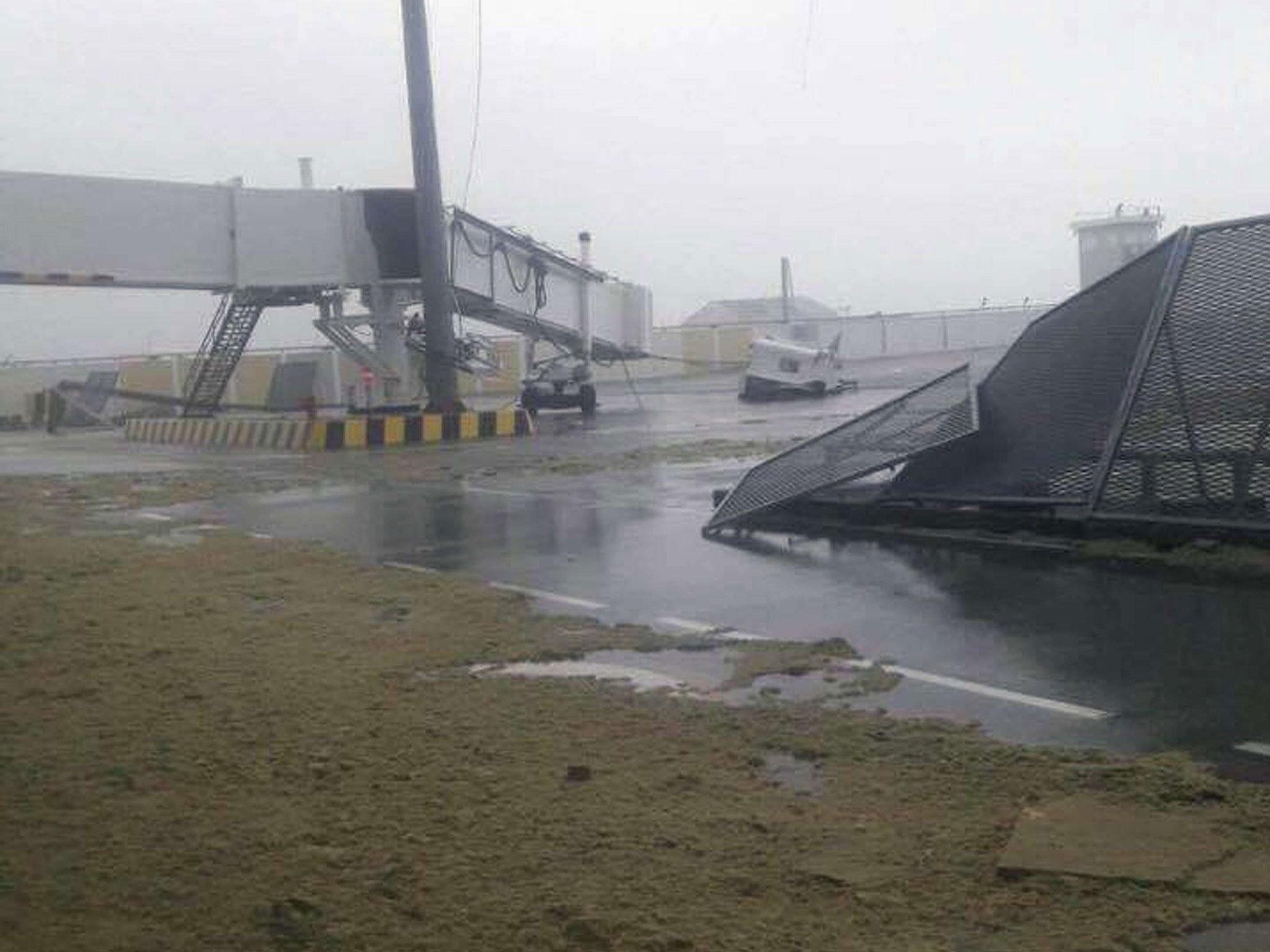 One of the airport's jet bridges was collapsed and its safety fences were pulled down, as its runway was left strewn with sand and debris