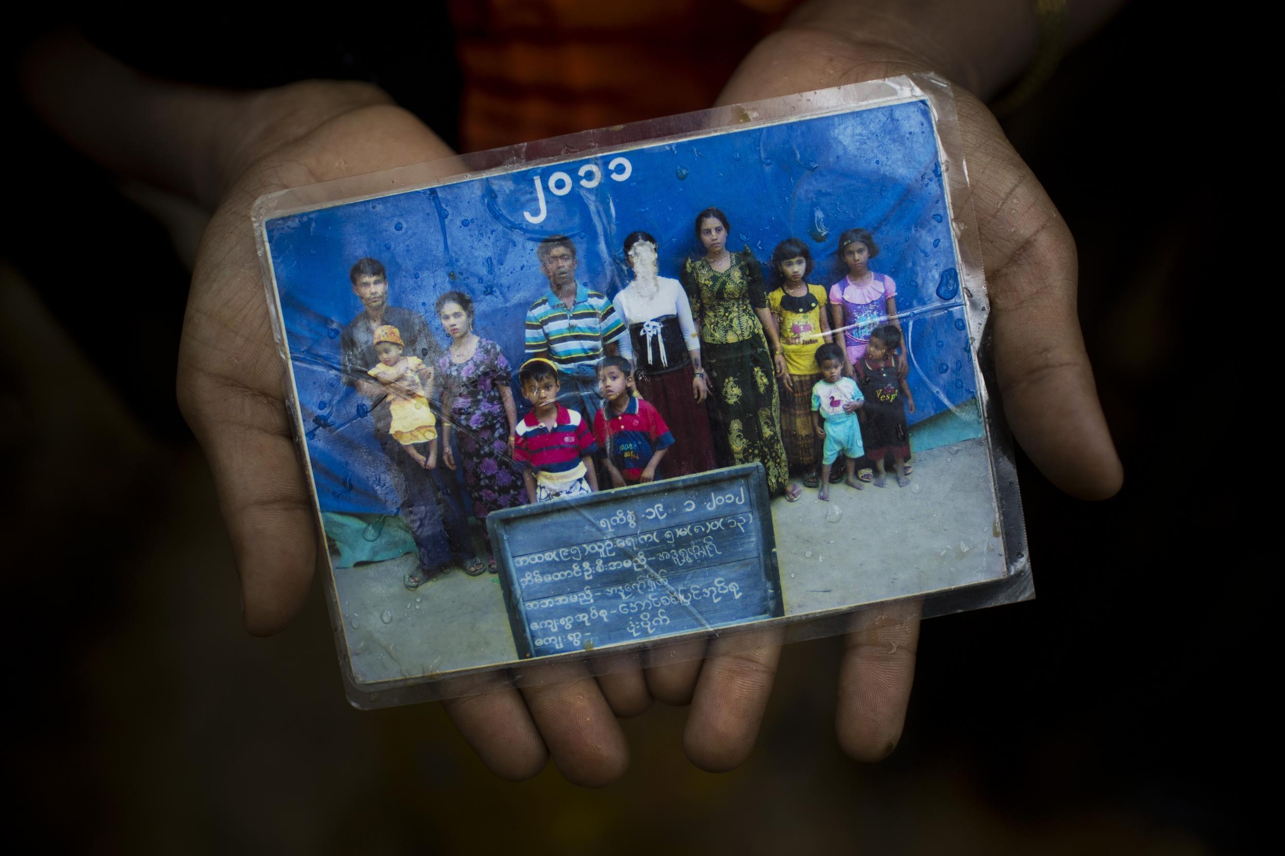 A woman holds a photograph of her family members