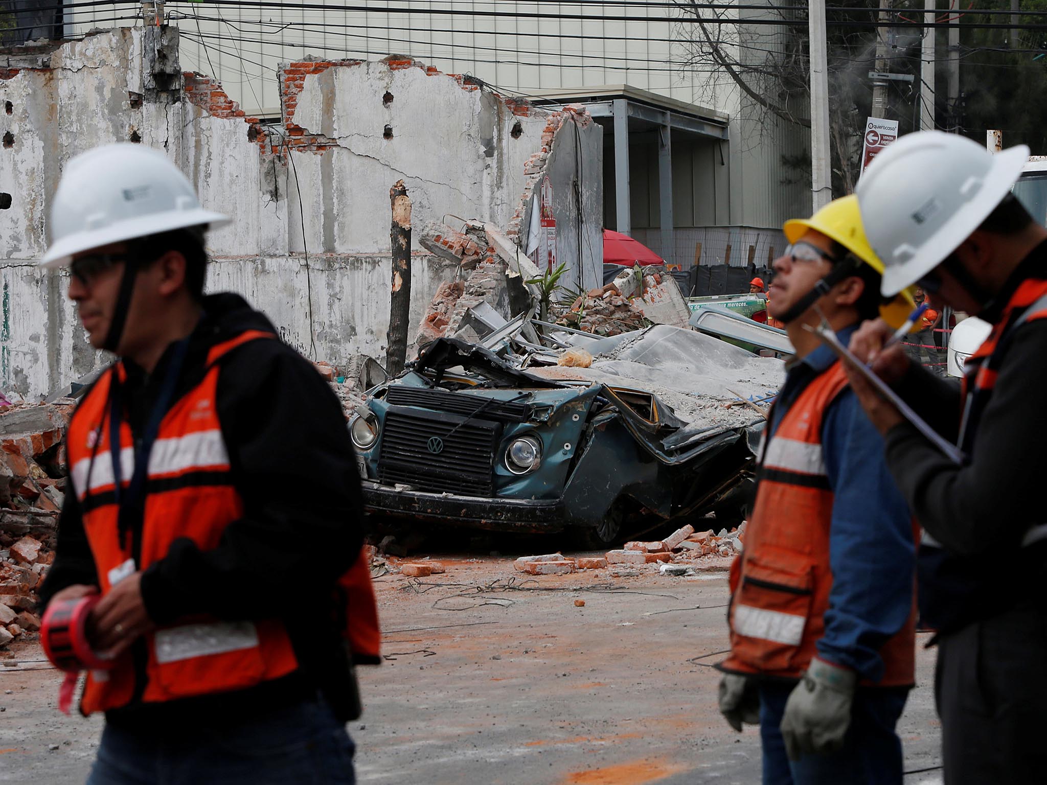 Workers survey the aftermath in Mexico City