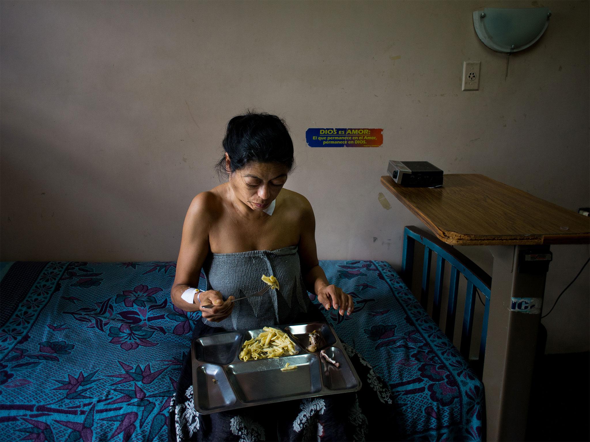 Laura Lopez eats her dinner – pasta and one chicken wing – at Central University Hospital in Caracas