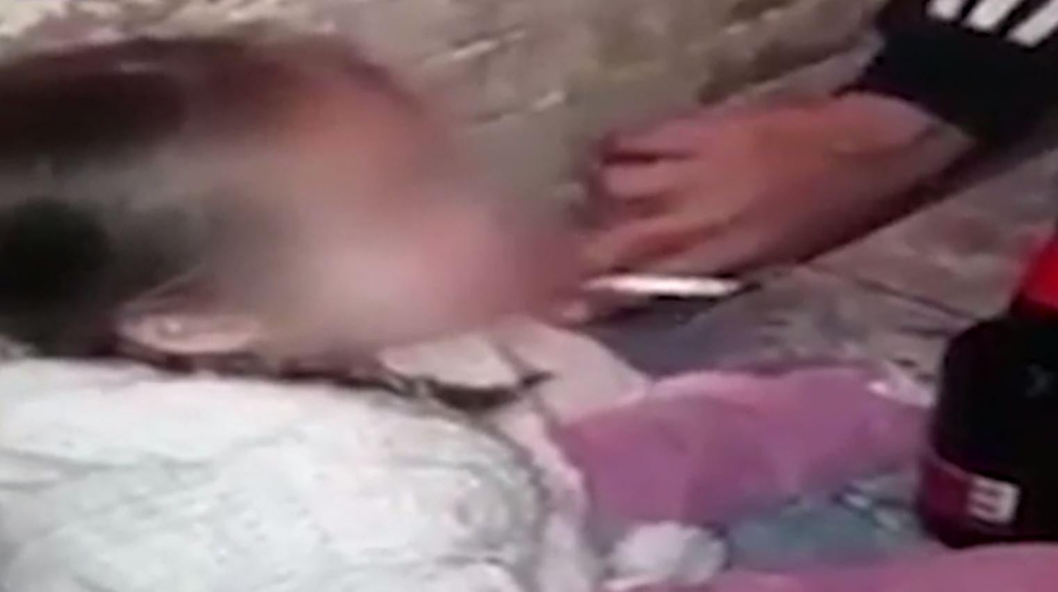 The young girl, aged around three-years-old, can be seen swaying as cigarettes and a beer bottle are held up to her mouth, while her parents can be heard laughing the background