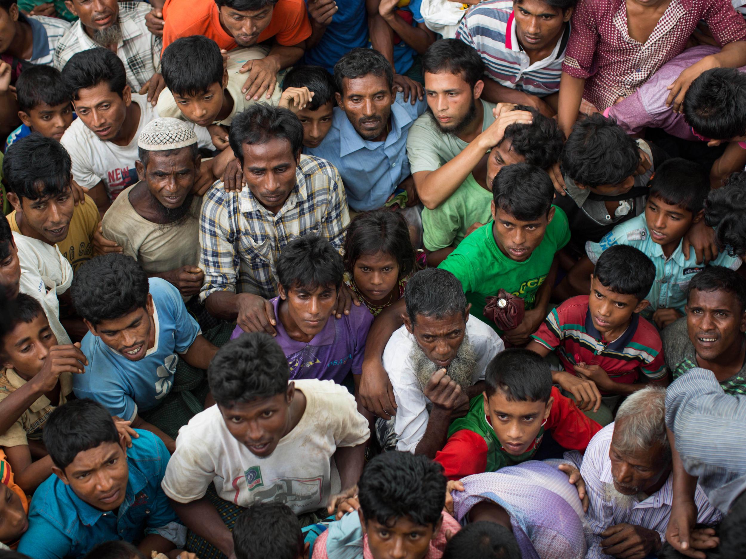 A young girl is squashed as Rohingya refugees wait for sacks of rice to be distributed in Whaikhyang, Bangladesh