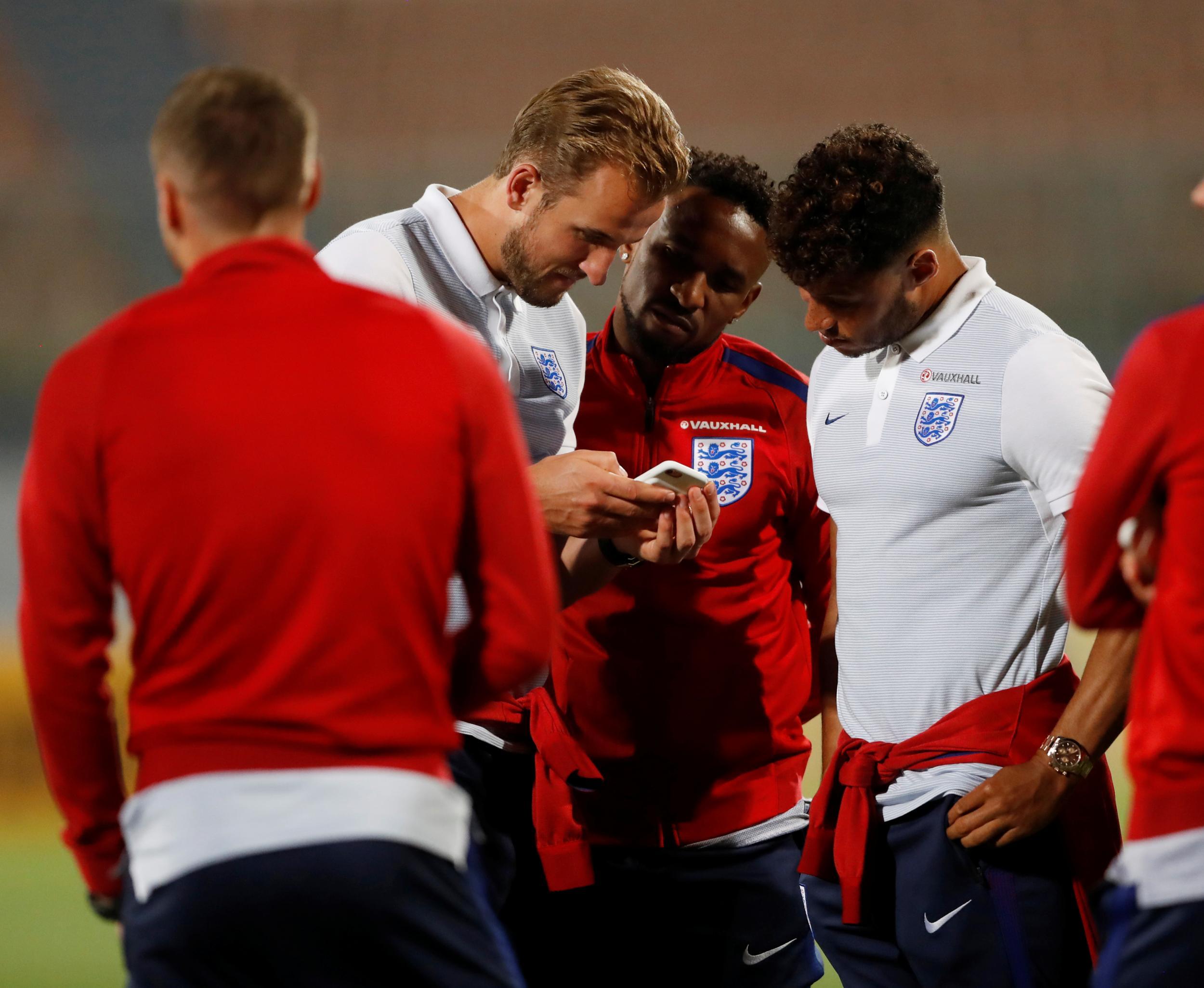 England's Alex Oxlade-Chamberlain, Harry Kane and Jermain Defoe look at a mobile phone during the stadium visit