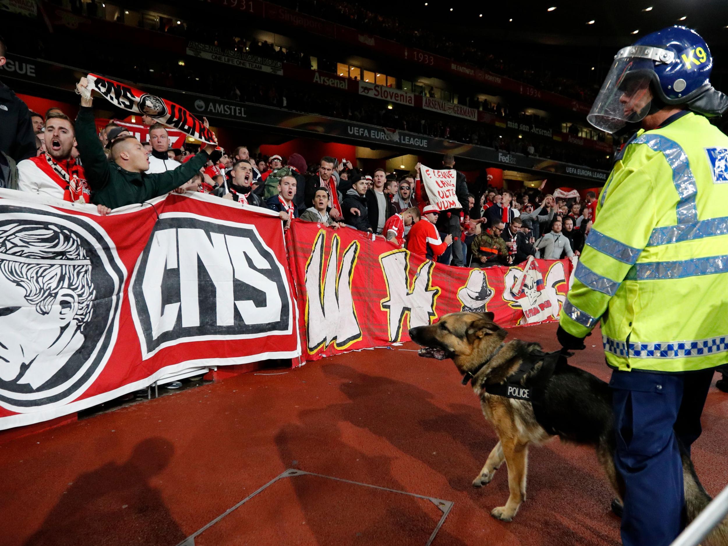 Police dogs guard fans at the away end at Emirates Stadium