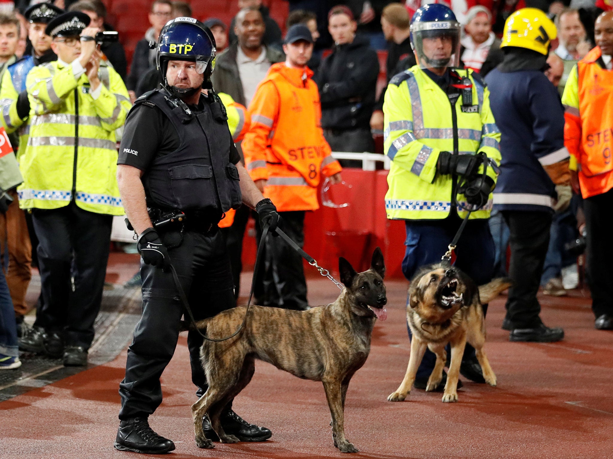 Police with dogs in front of Koln fans inside the Emirates stadium