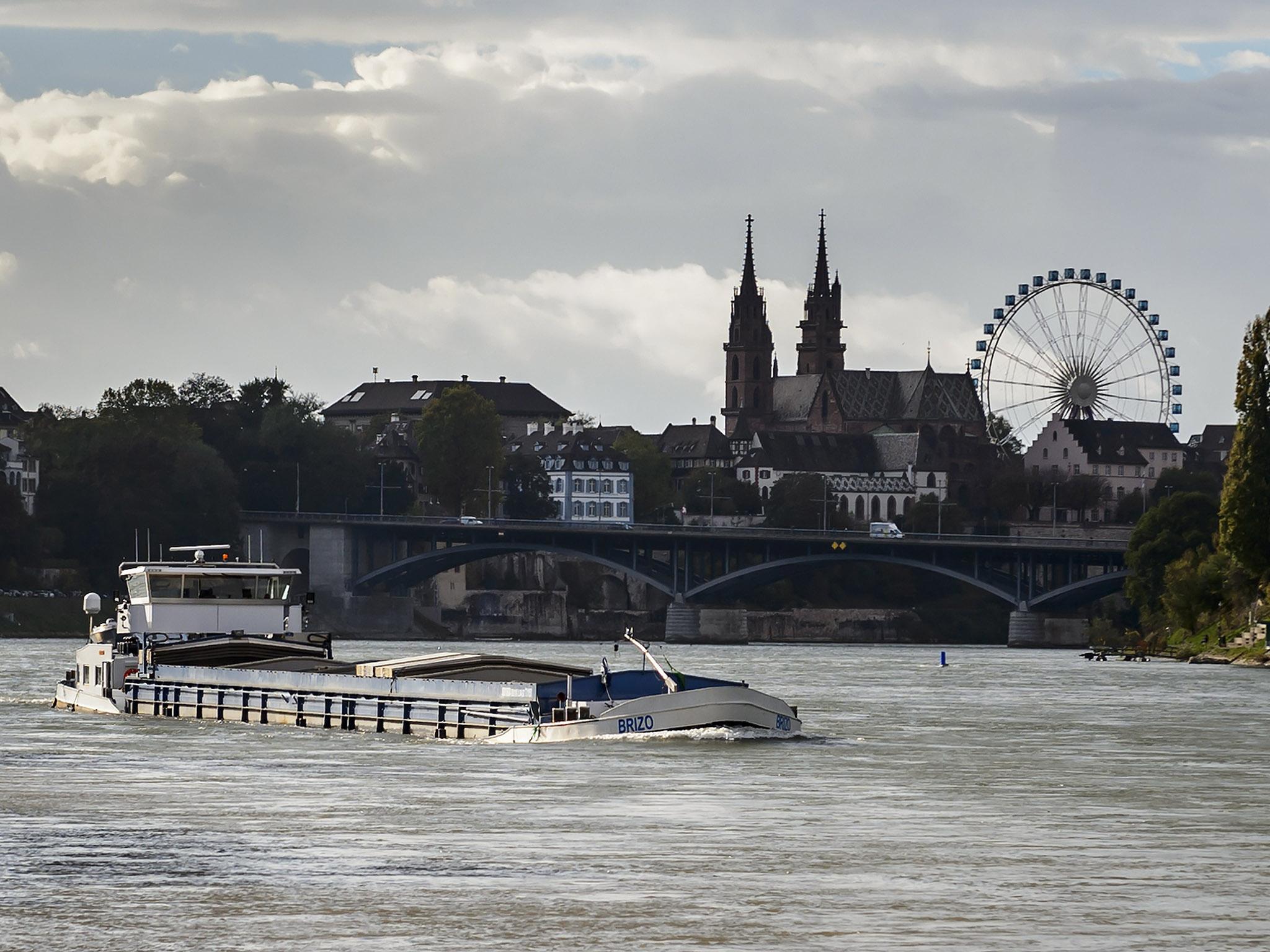 A barge on the river Rhine with Basel's cathedral in background