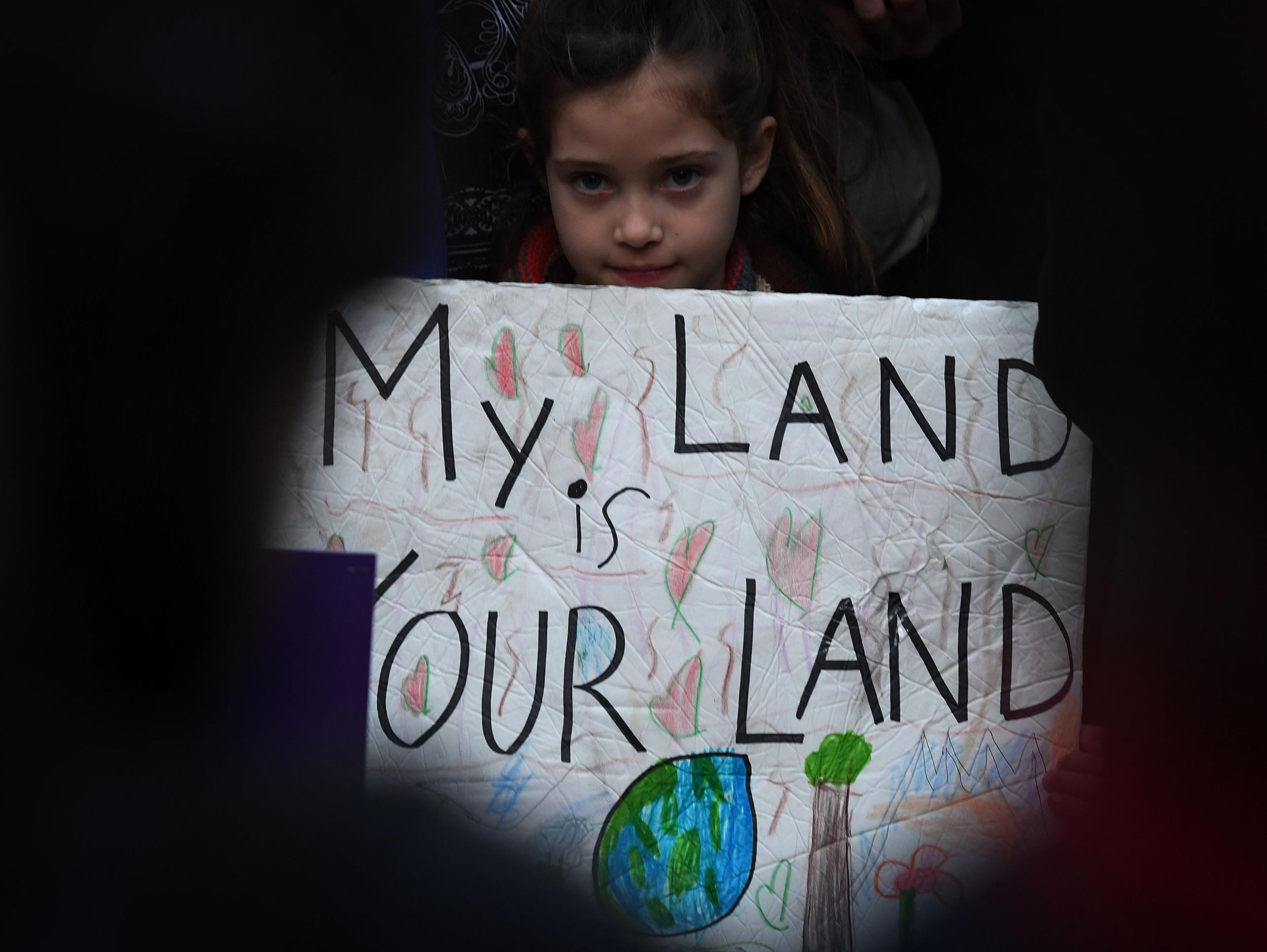 Maya Casillas, 7, joins migrant rights group during a vigil to protest against US President Donald Trump's new crackdown on 'sanctuary cities', outside the City Hall in Los Angeles