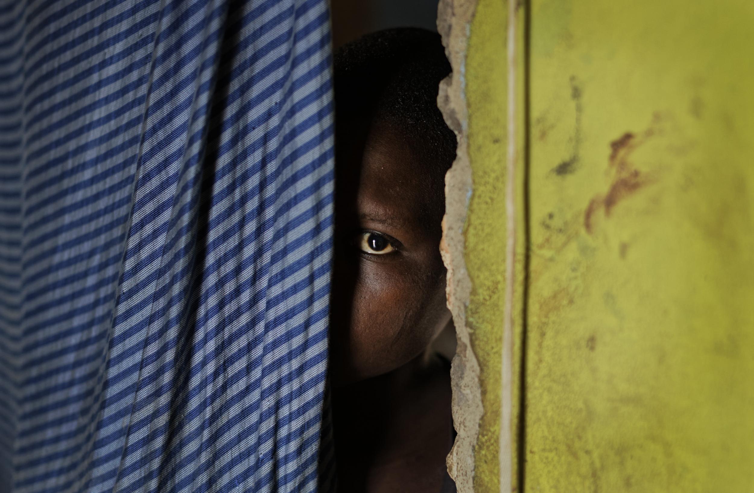 A 15-year-old who was raped when she was 14 talks to a member of UNICEF staff at her home in a village near Masaka, Uganda. The man who raped her was remanded to jail pending trial after an aid worker assisted her father in obtaining a birth certificate to prove she was under 18, a document she did not previously have