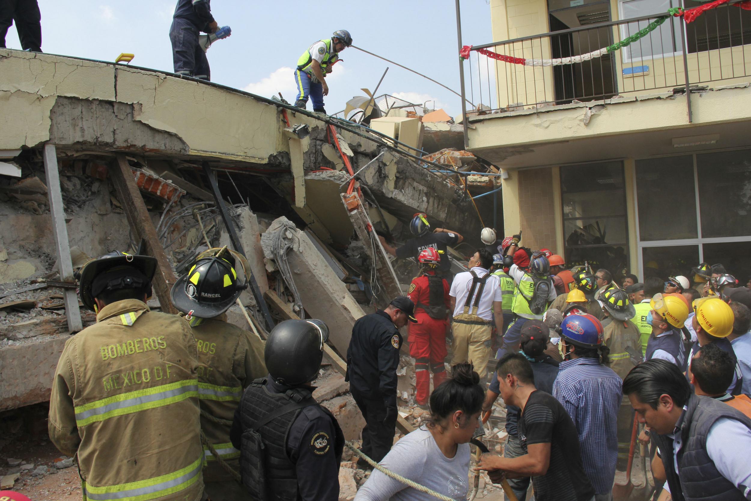 Rescue workers search for children trapped inside the collapsed Enrique Rebsamen school in Mexico City on Sept. 19, 2017.