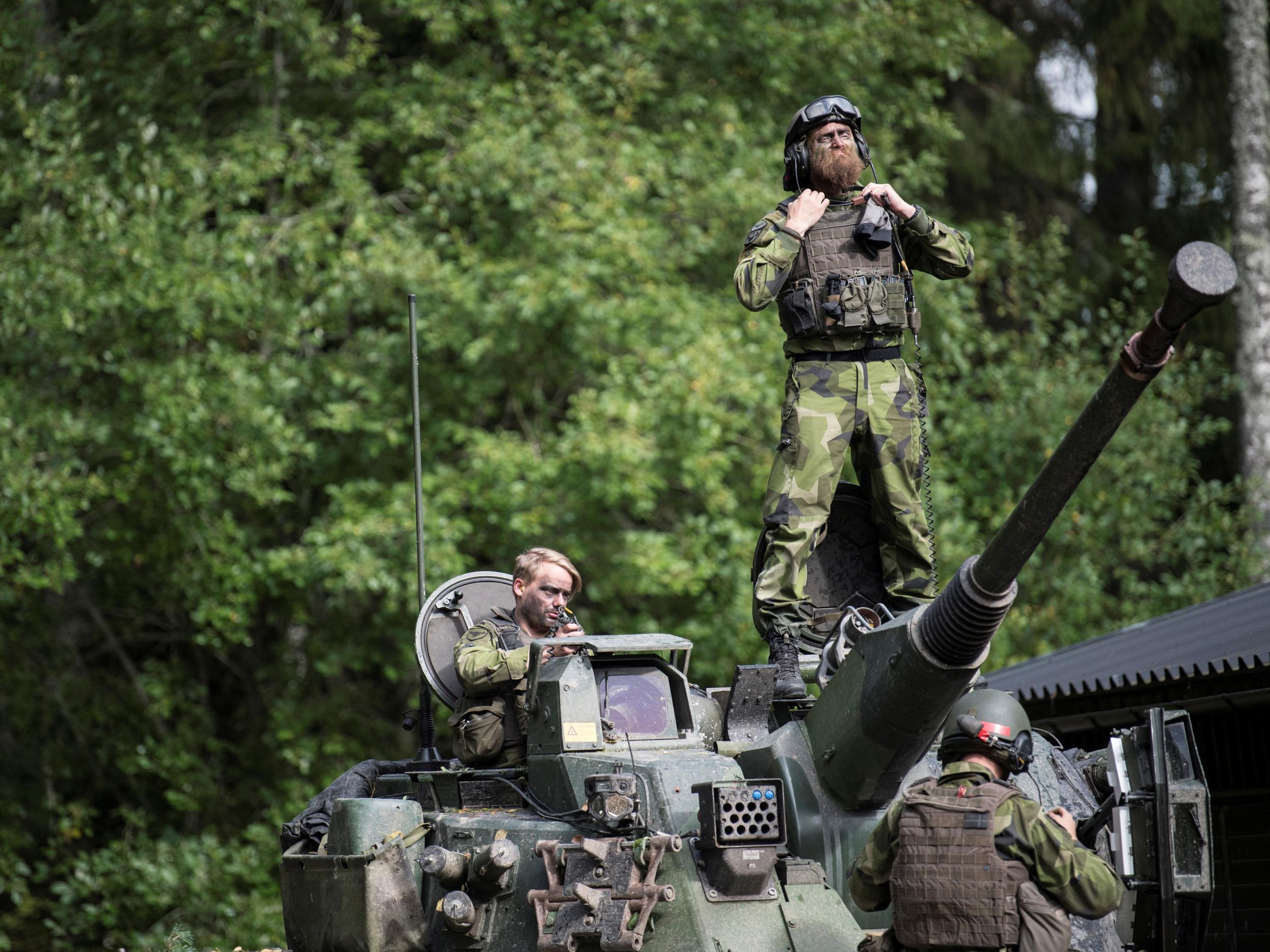 A Swedish soldier stands on a tank as Skaraborg's Swedish regiments practice with a US-enhanced armoured gun company in Skovde