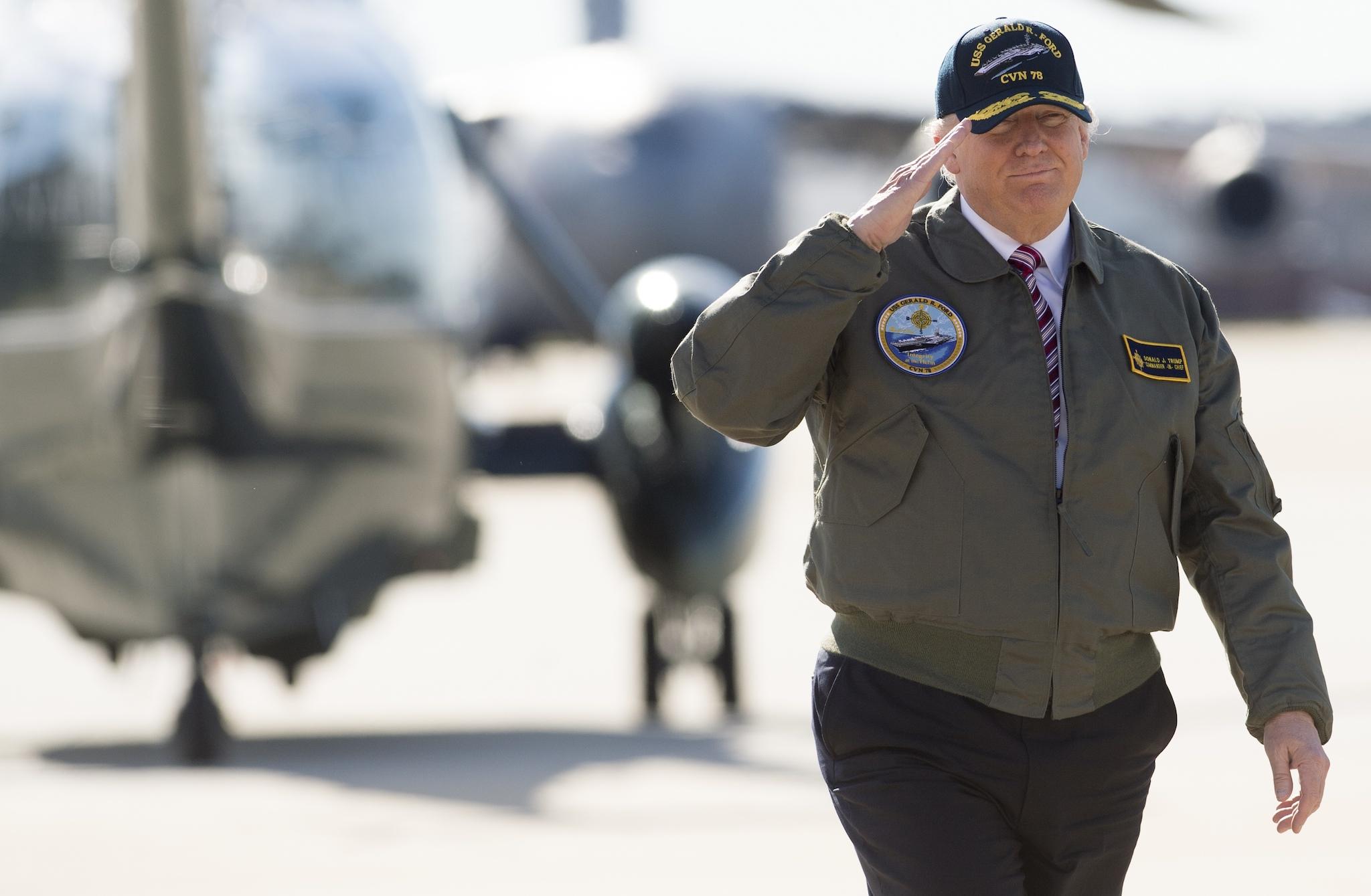 US President Donald Trump salutes as he walks to Air Force One prior to departing from Langley Air Force Base