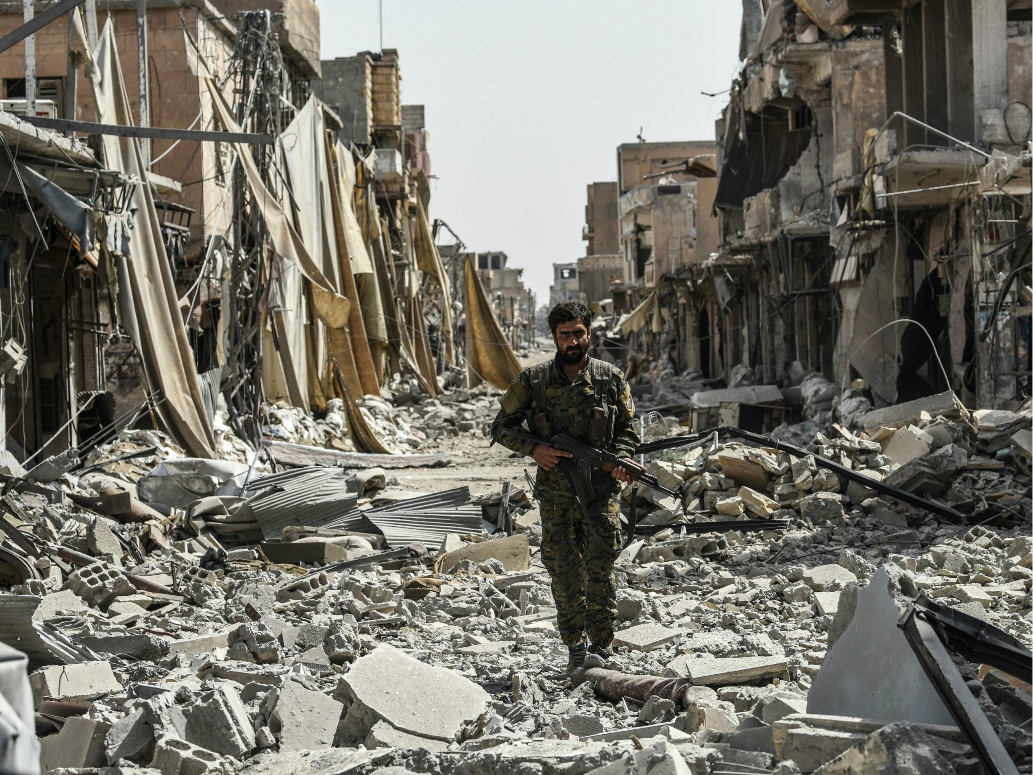 A member of the Syrian Democratic Forces walks through the debris in the old city centre on the eastern frontline of Raqqa on 25 September 2017