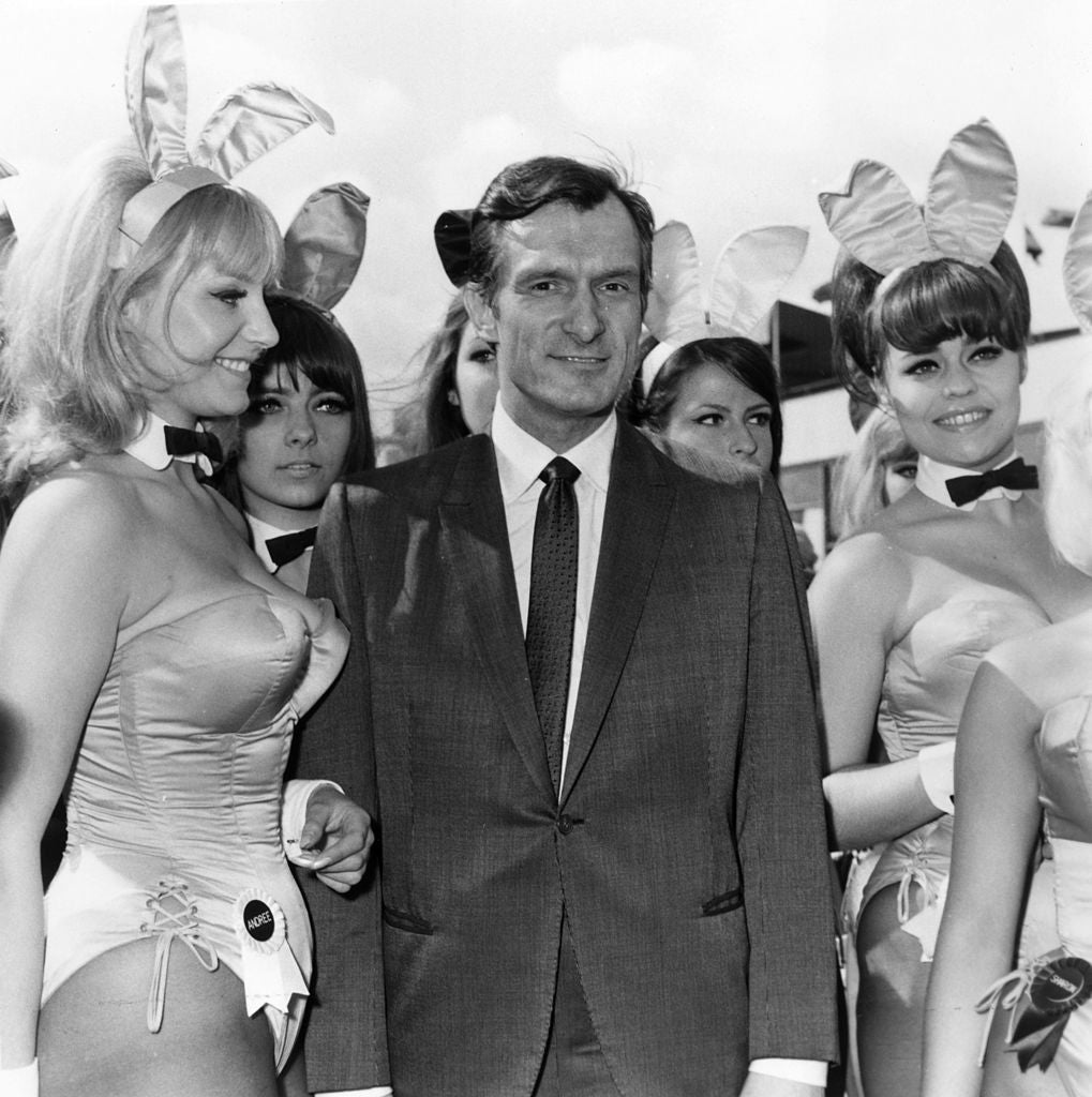 Playboy editor and tycoon Hugh Hefner is greeted by a group of bunny girls from his Playboy Clubs, upon his arrival at London Airport, 1966