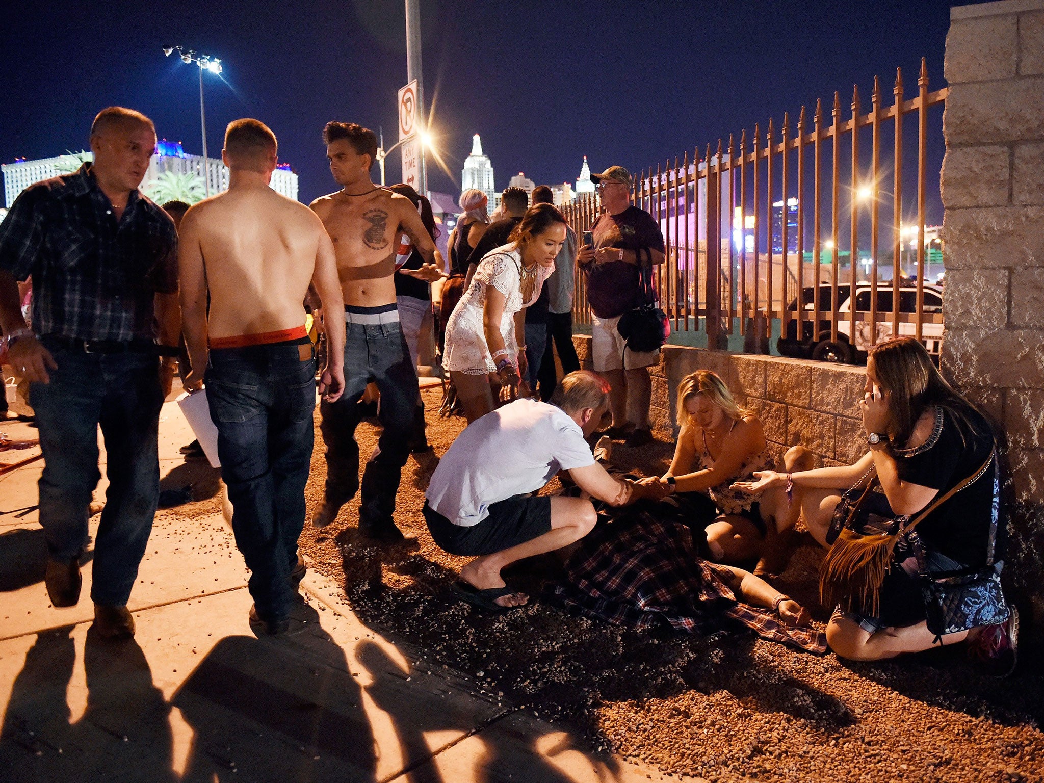 People tend to the wounded outside the festival ground after a mass shooting in Las Vegas, Nevada