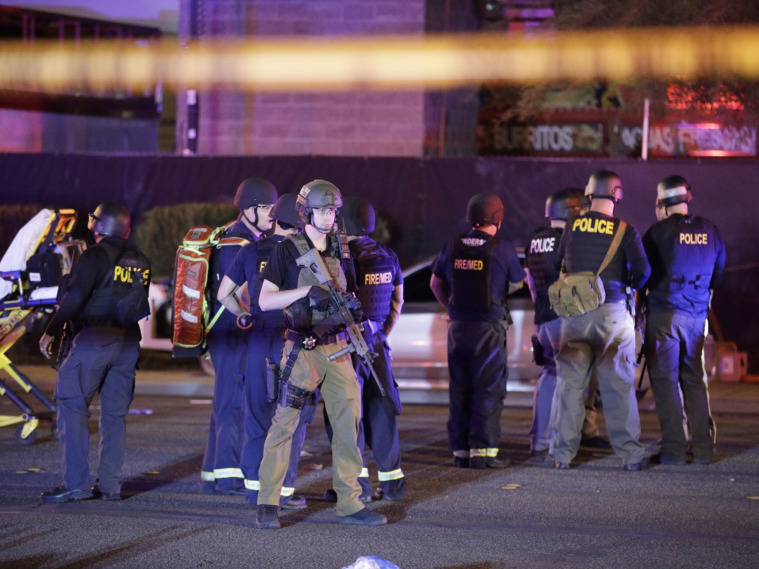 Police officers and medical personnel stand at the scene of a shooting near the Mandalay Bay resort and casino on the Las Vegas Strip.