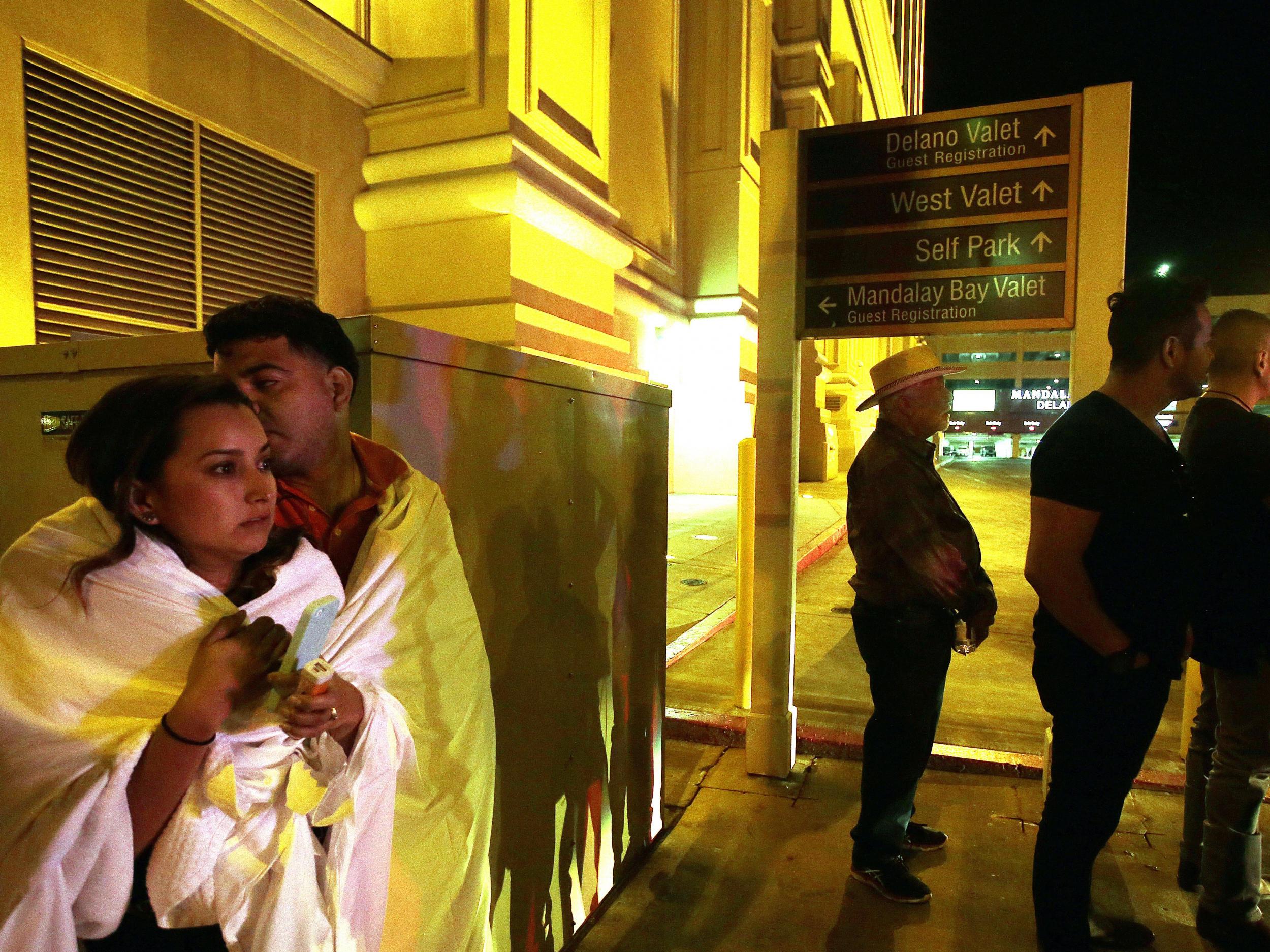 People stand on the street outside the Mandalay Bay hotel near the scene of the Route 91 Harvest festival on Las Vegas Boulevard