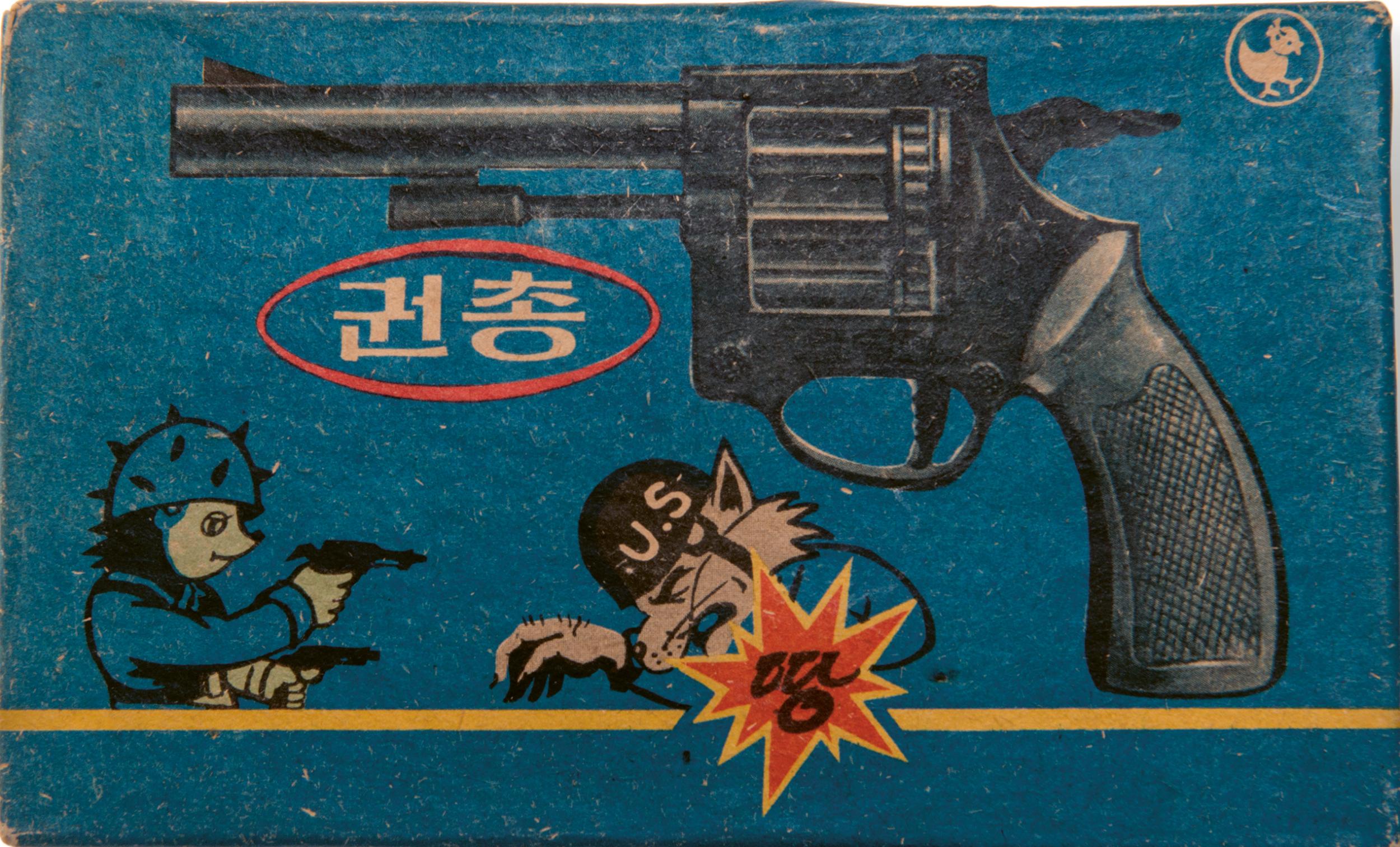 The packaging for a toy gun featuring an anti-US cartoon