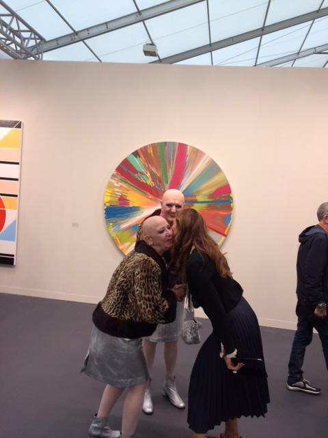 A fond embrace in front of a Damien Hirst Spin painting at 2017’s Frieze Art Fair in London