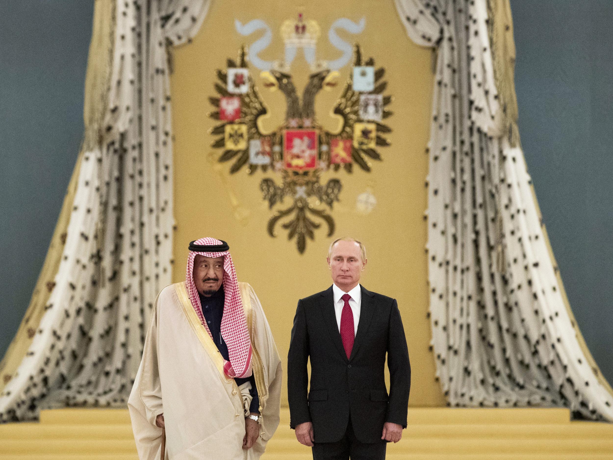 Saudi King Salman bin Abdulaziz and Russian President Vladimir Putin listen to national anthems during their meeting at the Kremlin