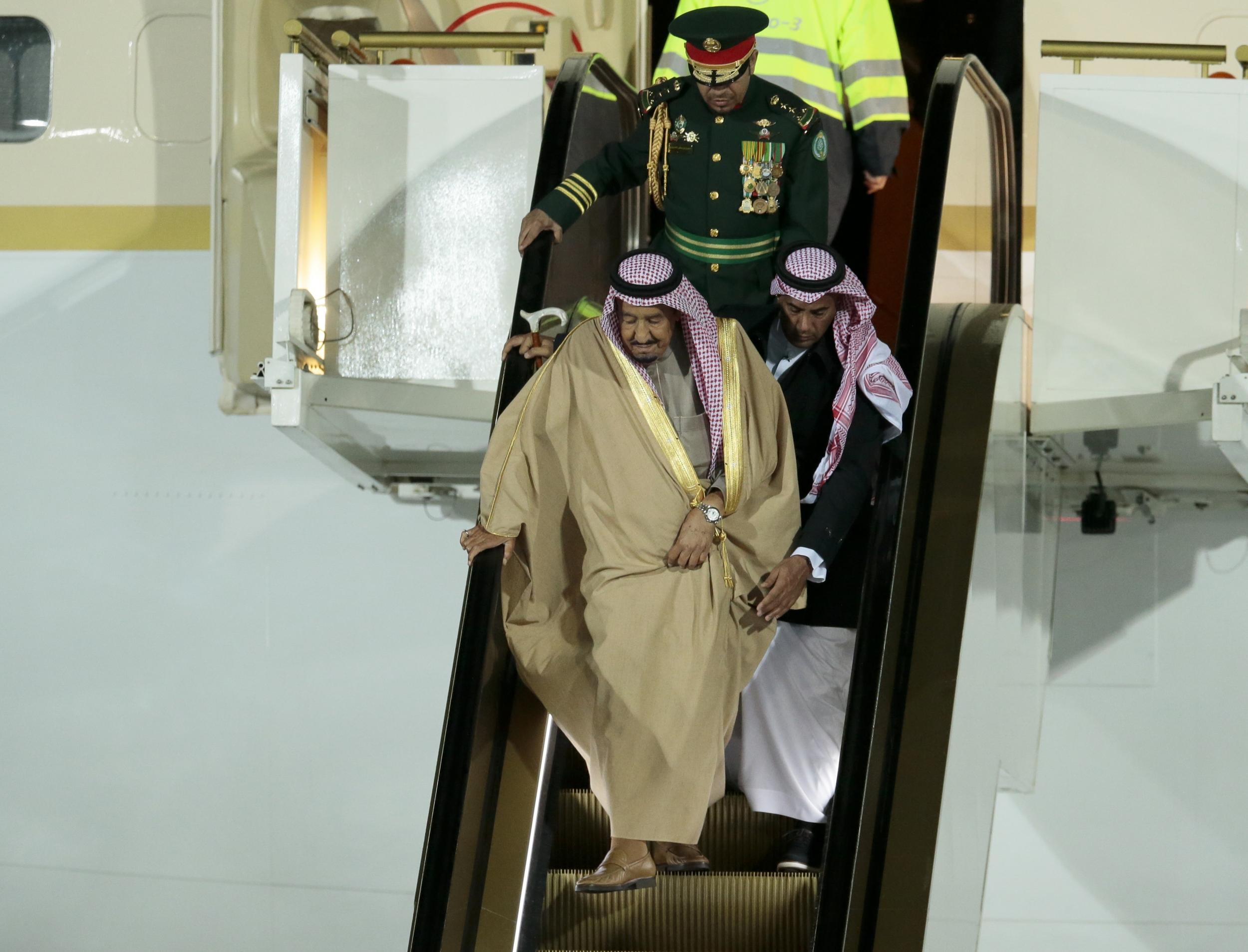 Saudi King Salman is helped down the broken escalator by aides (AP )