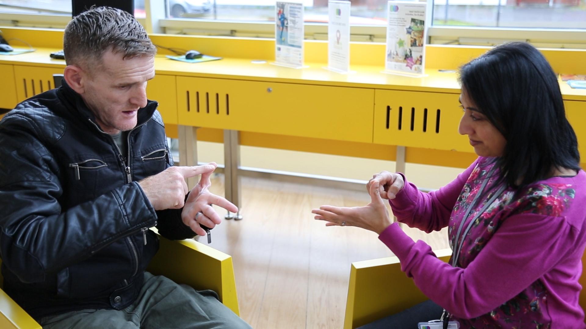 Ahmad works on how to spell his name in BSL with Bhavana