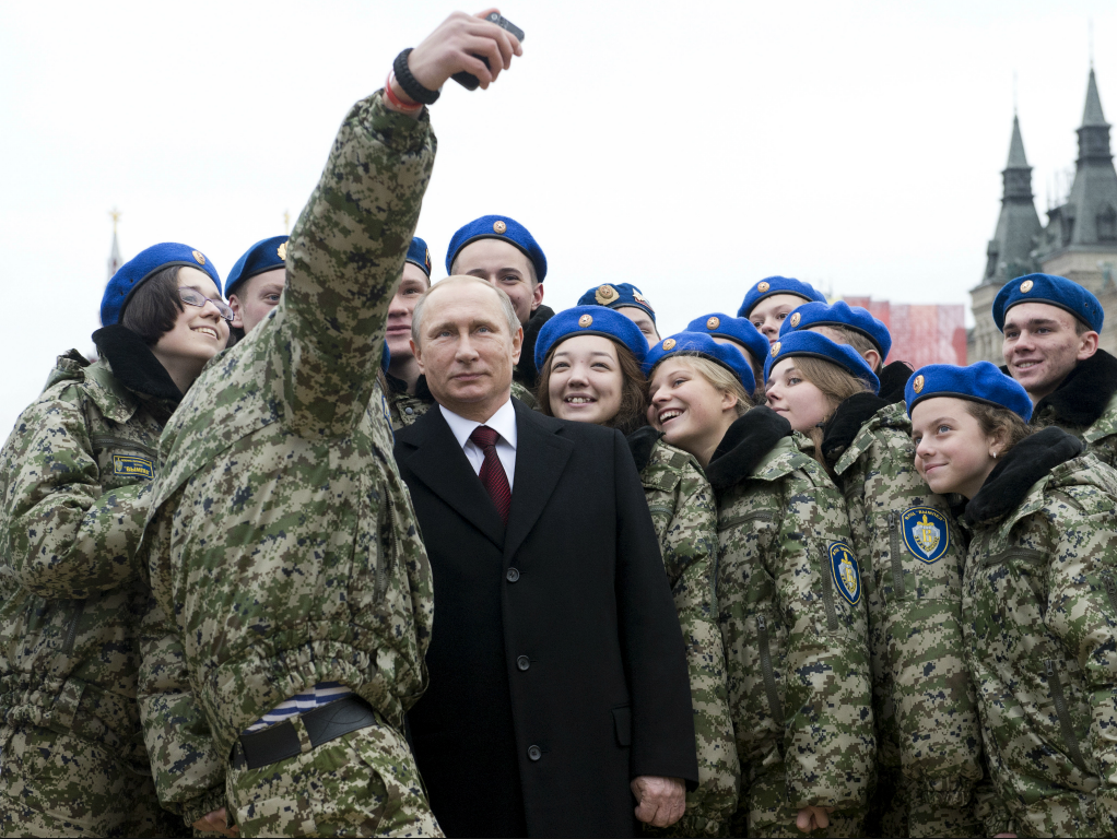 Russian Prime Minister Vladimir Putin poses for a selfie with members of a youth military patriotic club in 2015