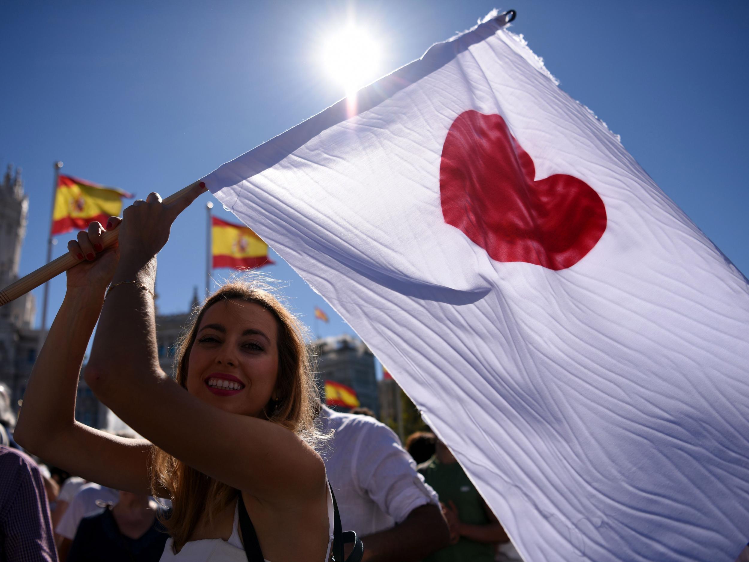 A woman holds a white flag during a demonstration at Cibeles square in Madrid, called by the ‘Let's talk’ association for dialogue in Catalonia