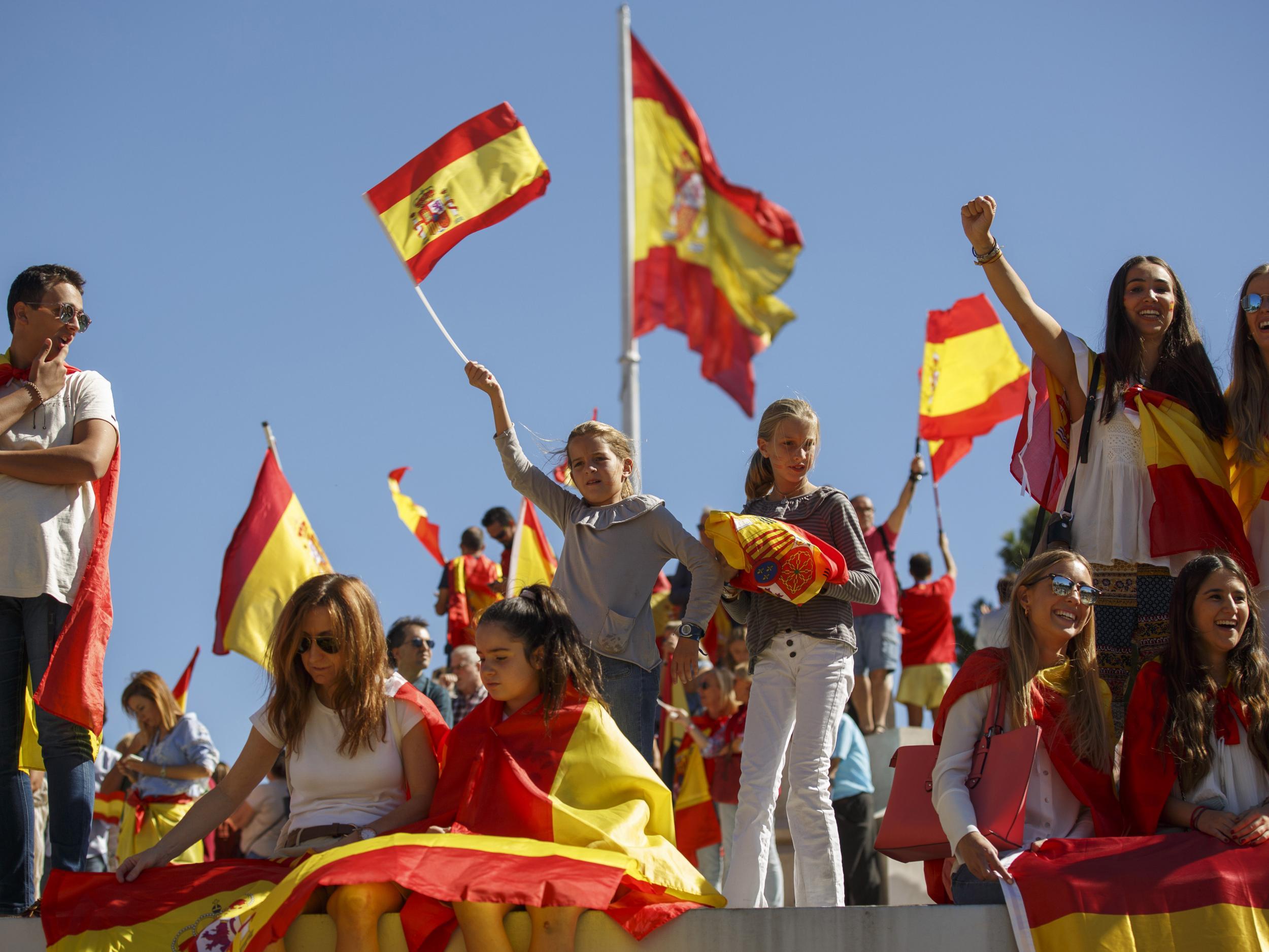 Pro-unity demonstrators hold Spanish flags at Colon Square in Madrid