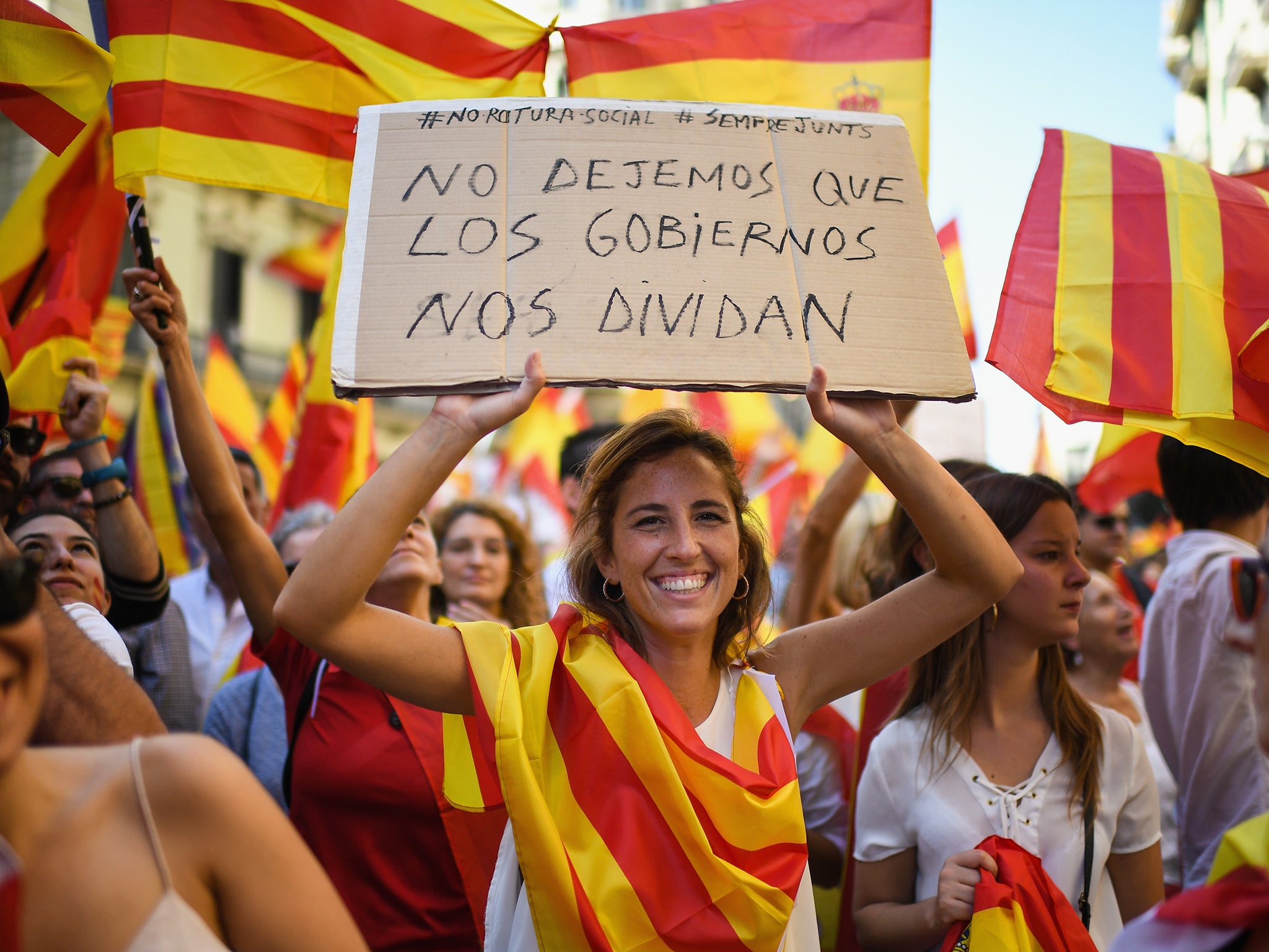 Pro-unity supporters march through Barcelona carrying a sign that reads: 'Let's not let governments divide us'