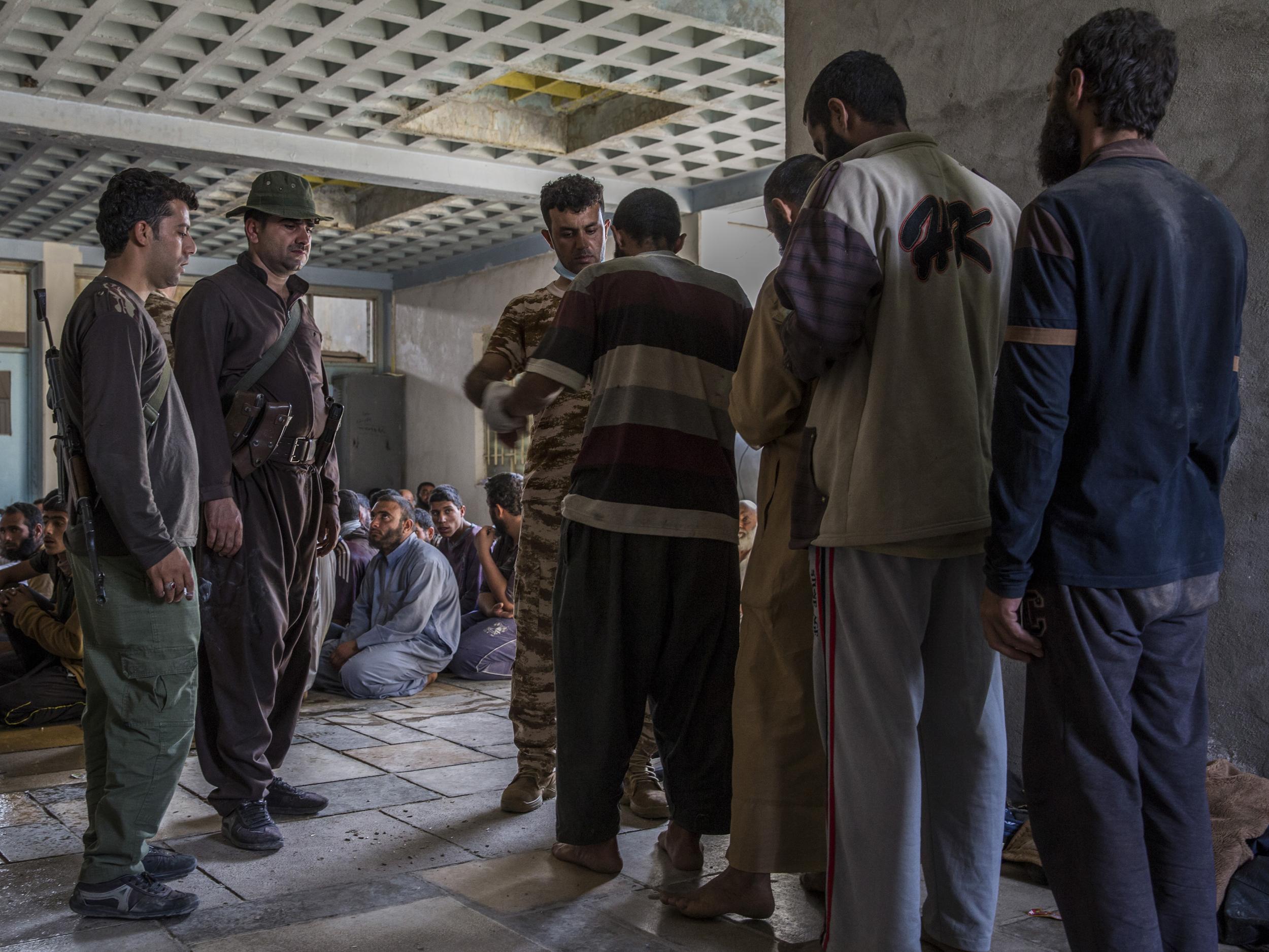 Men suspected of being Isisfighters are searched at a security screening centre near Kirkuk, Iraq