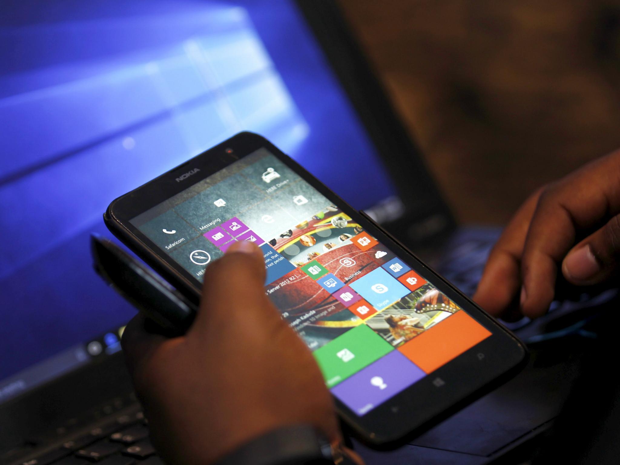 A Microsoft delegate checks applications on a smartphone during the launch of the Windows 10 operating system in Kenya's capital Nairobi, July 29, 2015