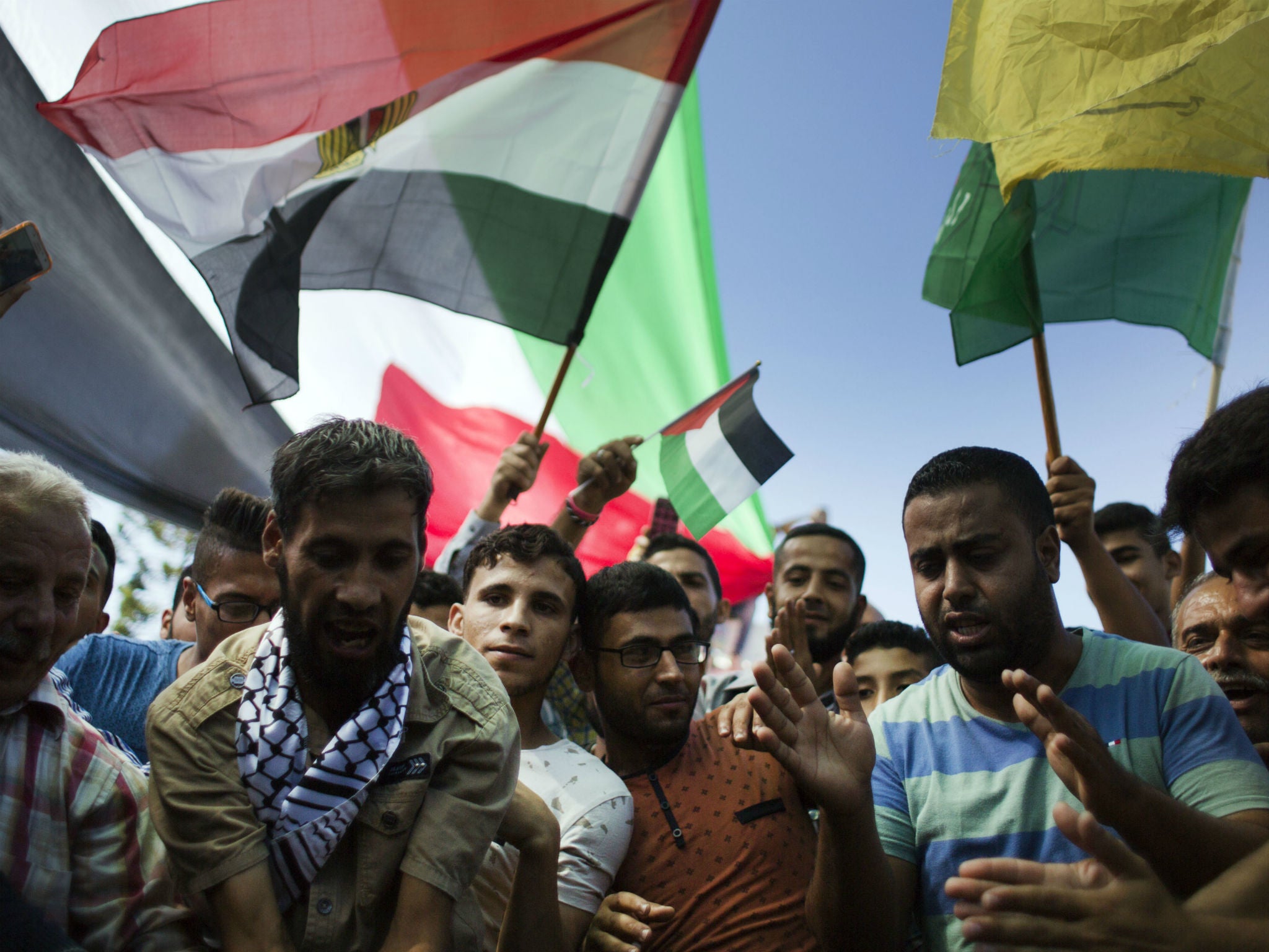 Palestinians wave National and Egyptian flags as they celebrate the reconciliation agreement between Hamas and Fatah in Gaza City