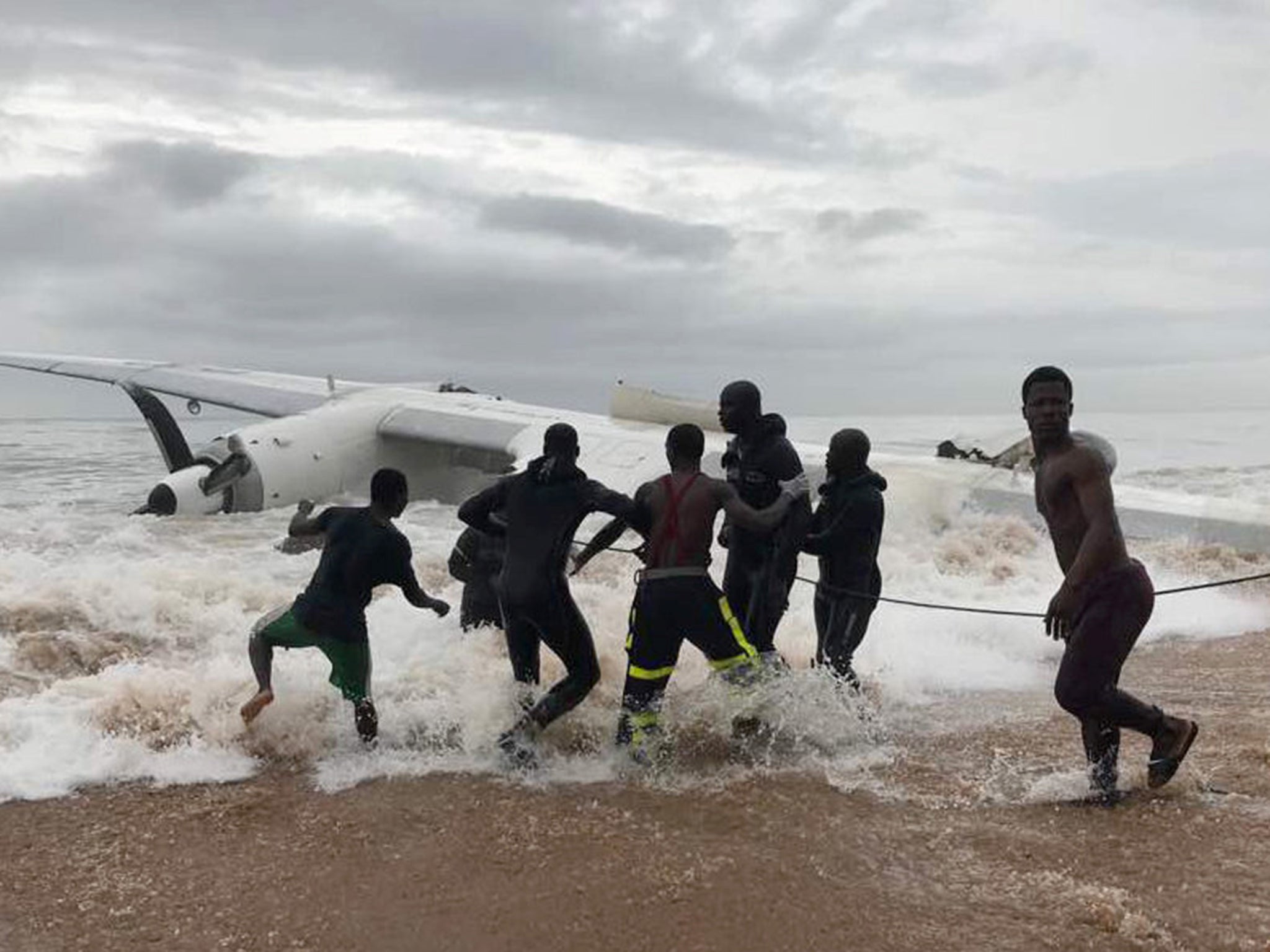 People pull the wreckage of a propeller-engine cargo plane after it crashed in the sea near the international airport in Ivory Coast's main city, Abidjan