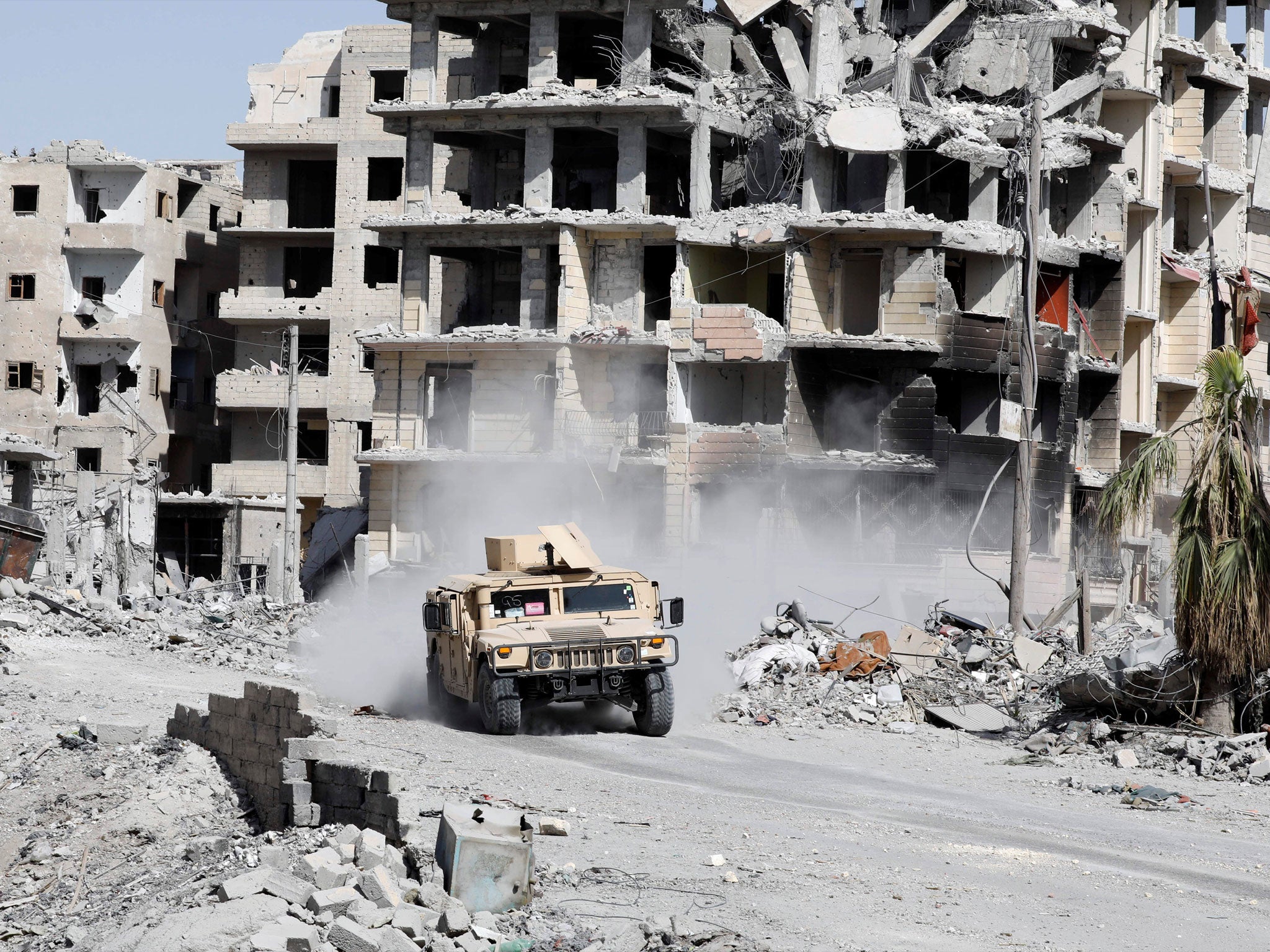 An armoured vehicle of the Syrian Democratic Forces is seen along a road at the frontline in Raqqa