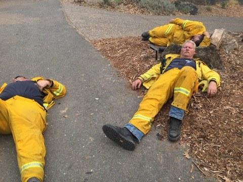 Exhausted firefighters try to get some rest on the ground using rocks as pillows (Sebastopol Fire Department/Facebook)