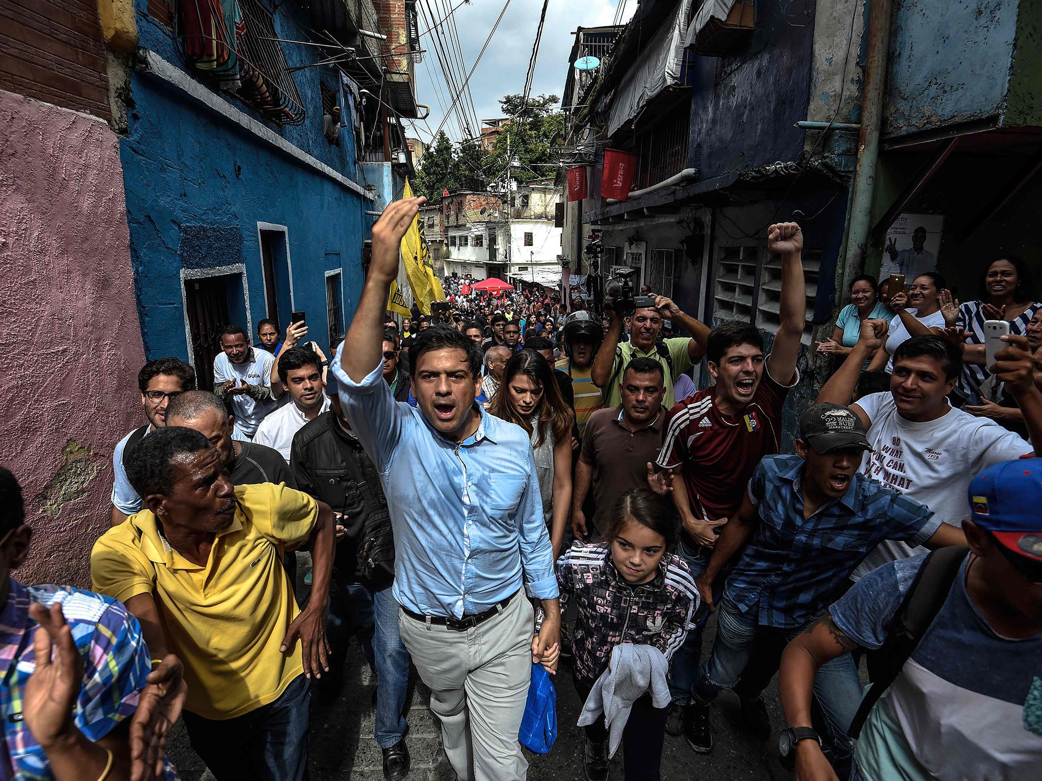 The opposition's candidate for governor for the state of Miranda, Mayor of Caracas' Sucre Municipality Carlos Ocariz (C) greets supporters