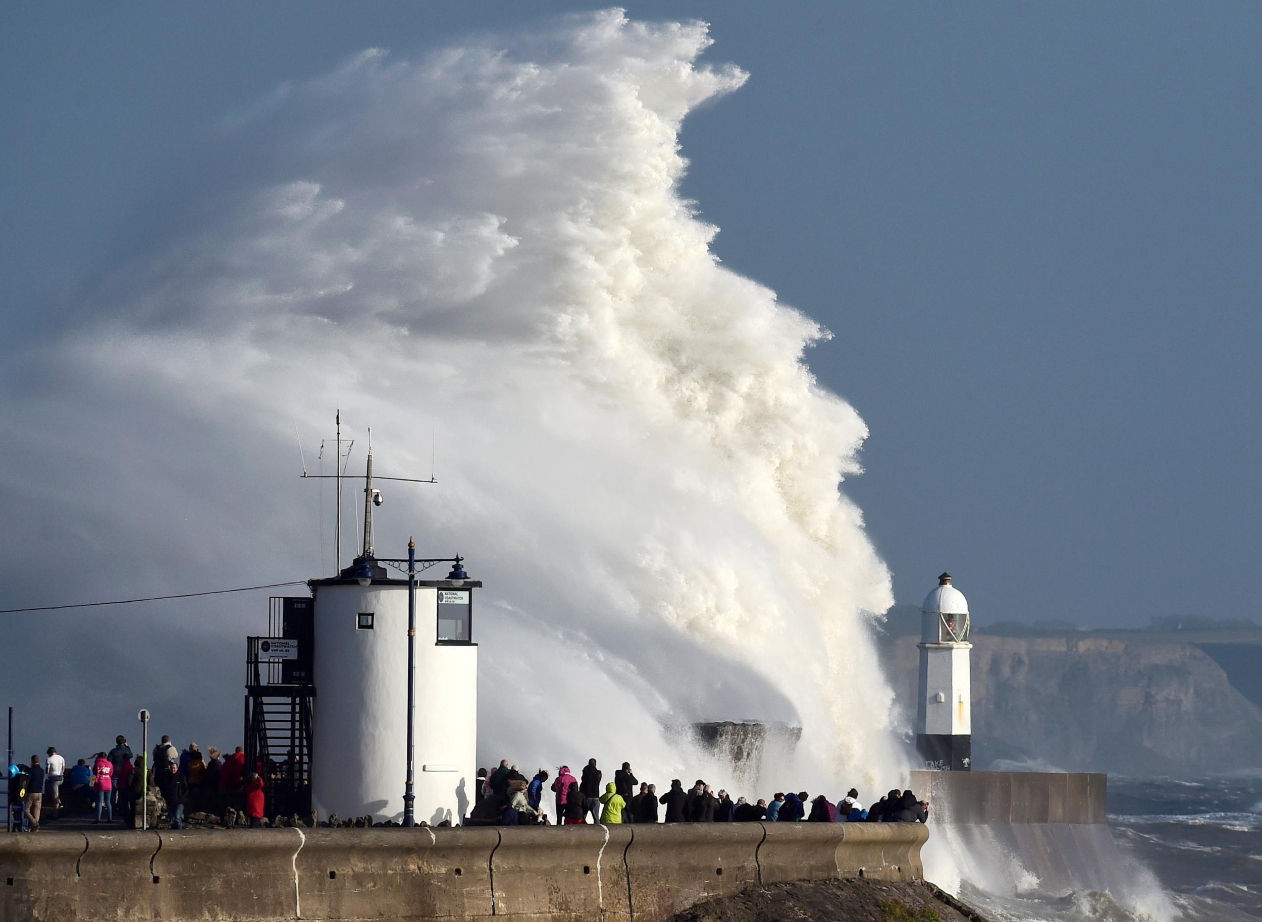 Waves crash over a lighthouse as Storm Ophelia passes Porthcawl. UK storms do cause damage and distress, but now they are being elevated into a big worry on a regular basis