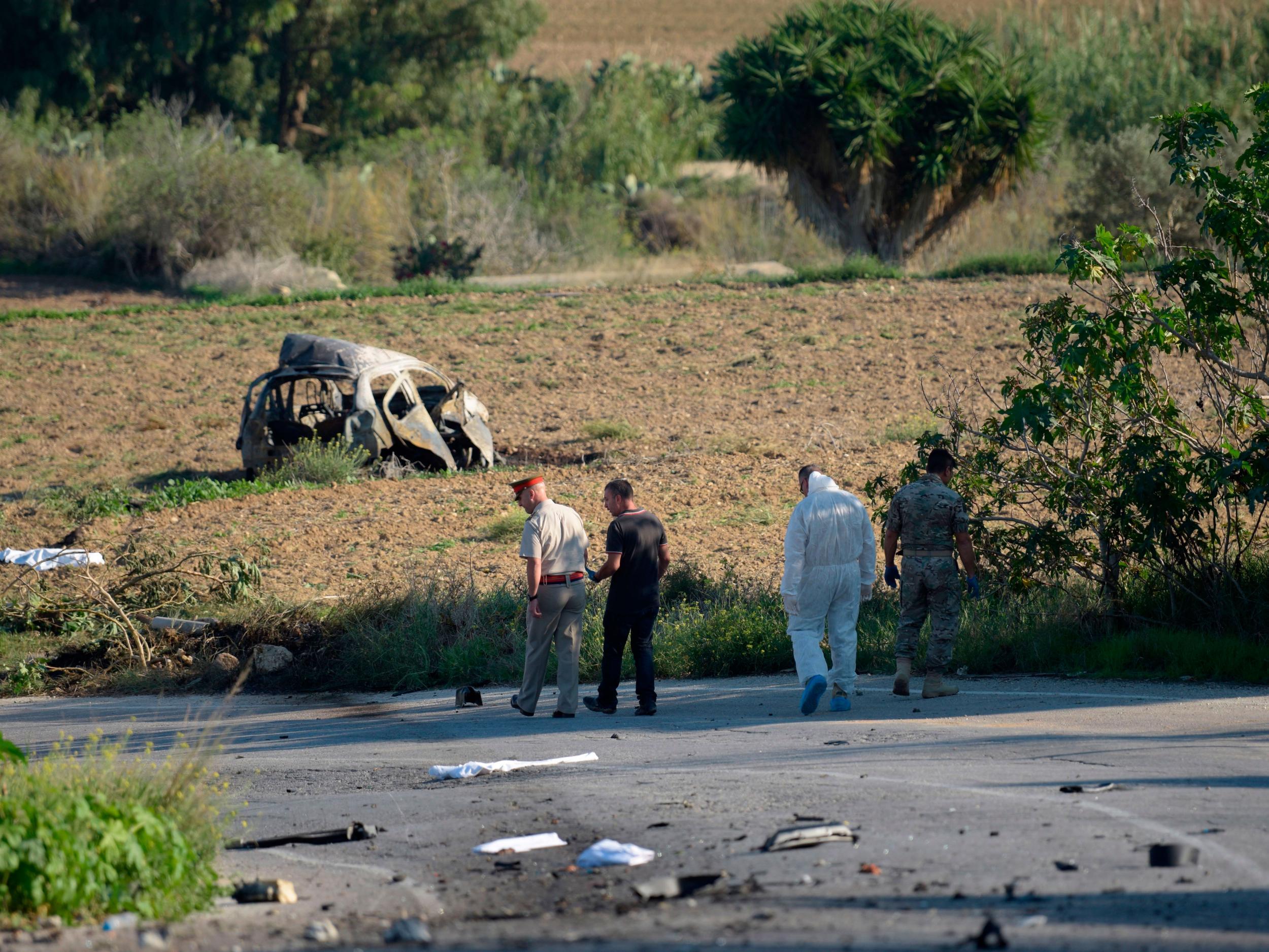 Police and forensic experts inspect the wreckage after a car bomb killed Ms Galizia (Getty)