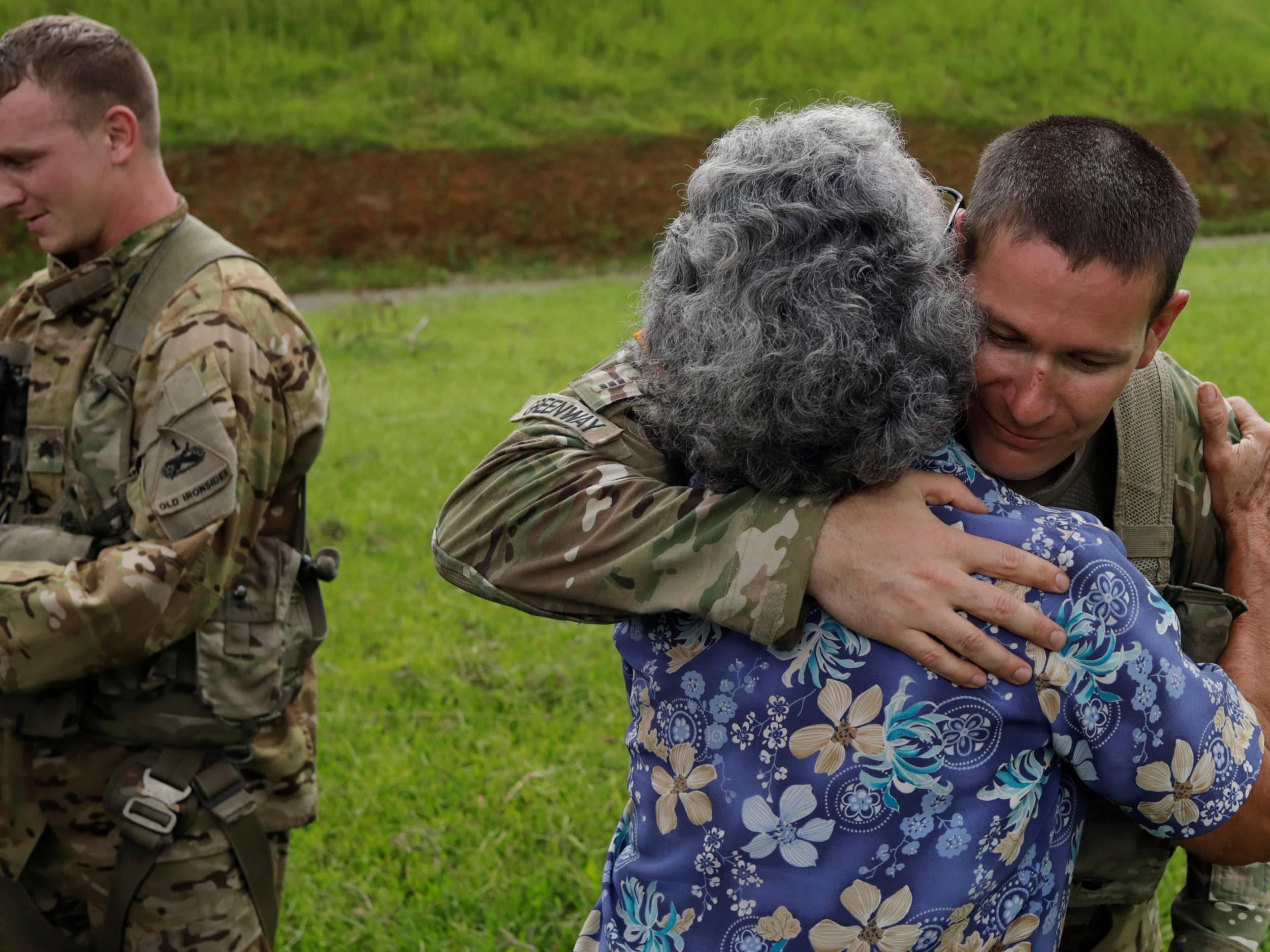 UH-60 Blackhawk helicopter pilot Chris Greenway receives a hug from a woman thanking him for water as he works with the First Armored Division's Combat Aviation Brigade during recovery efforts following Hurricane Maria, in Verde de Comerio, October 7, 2017