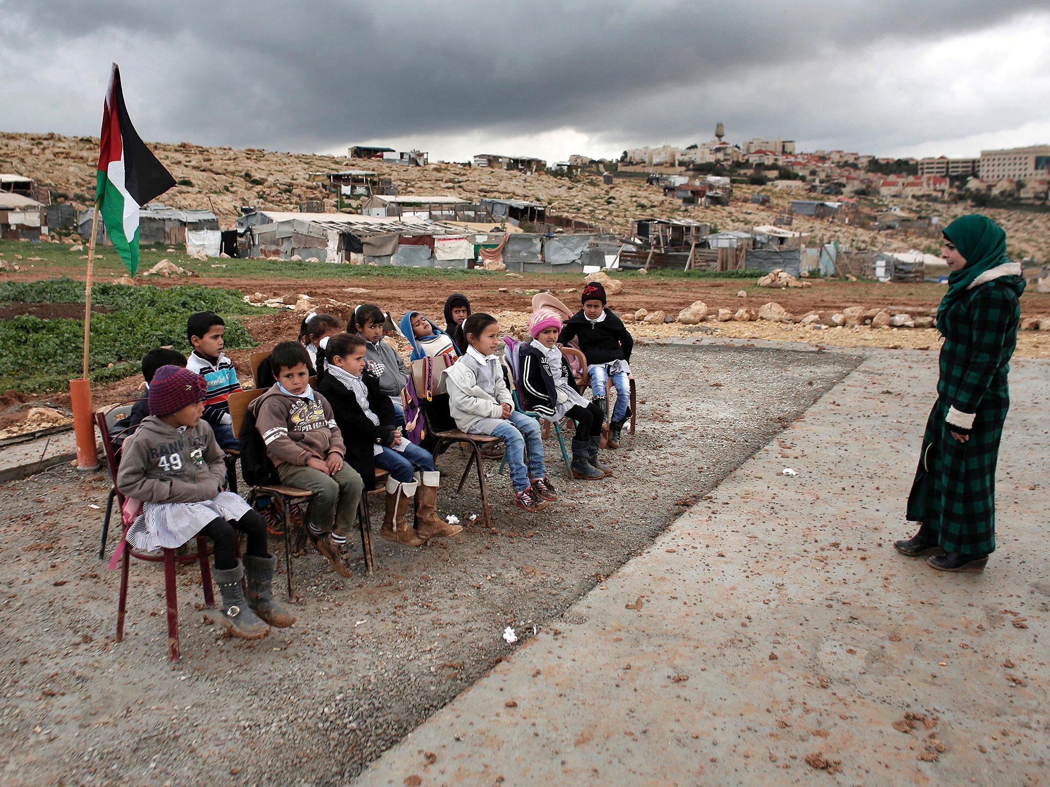 A class of Palestinian Bedouin children attend school outside after the Israeli Army forces dismantled prefabricated classrooms