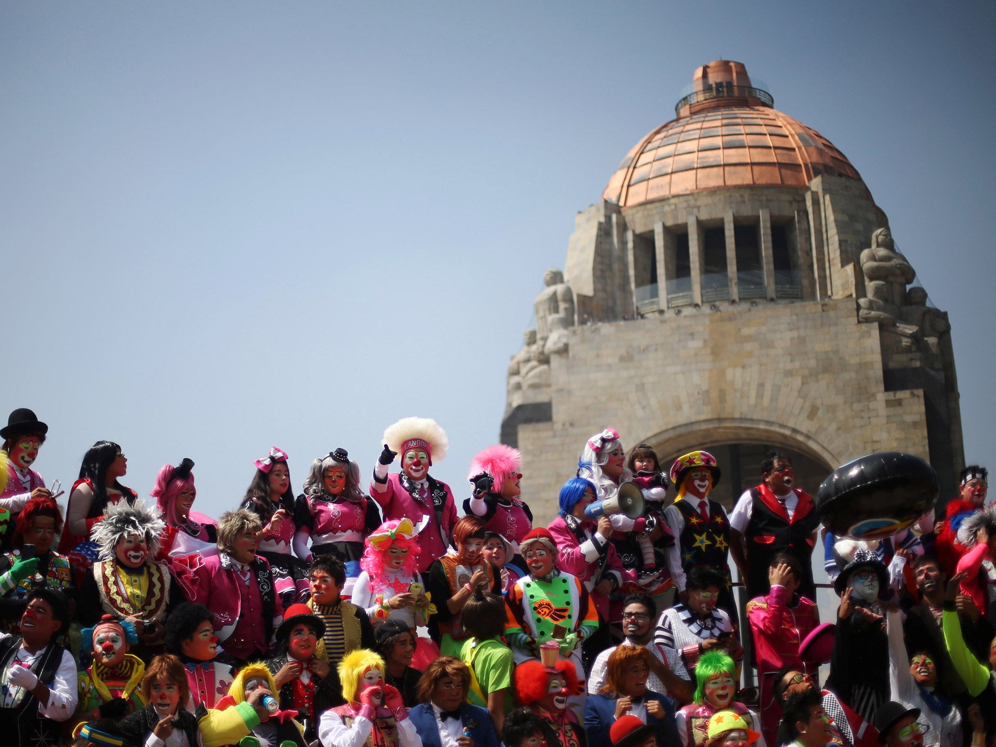 Clowns take part in the 22nd Latin American clown convention at Revolucion monument in Mexico City