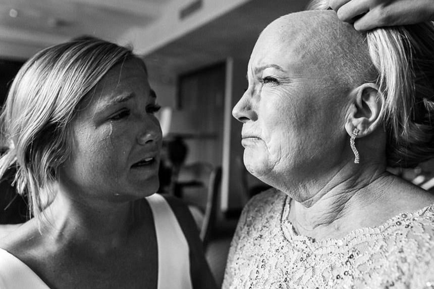 A bride tearfully watches asher mother has a wig placed on her head