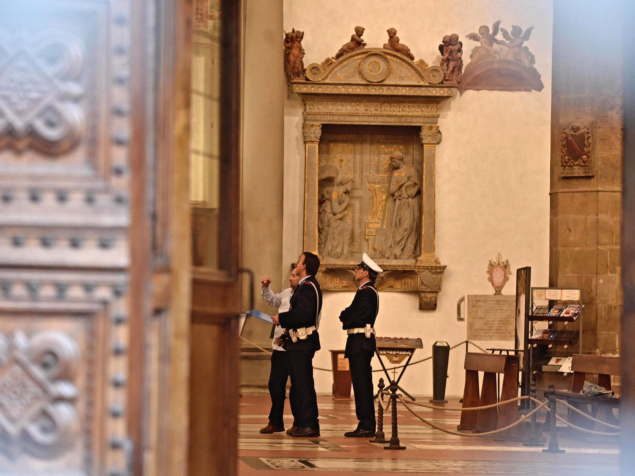 Police stand inside Santa Croce Basilica where a 52-year-old Spanish tourist was killed after being struck by masonry