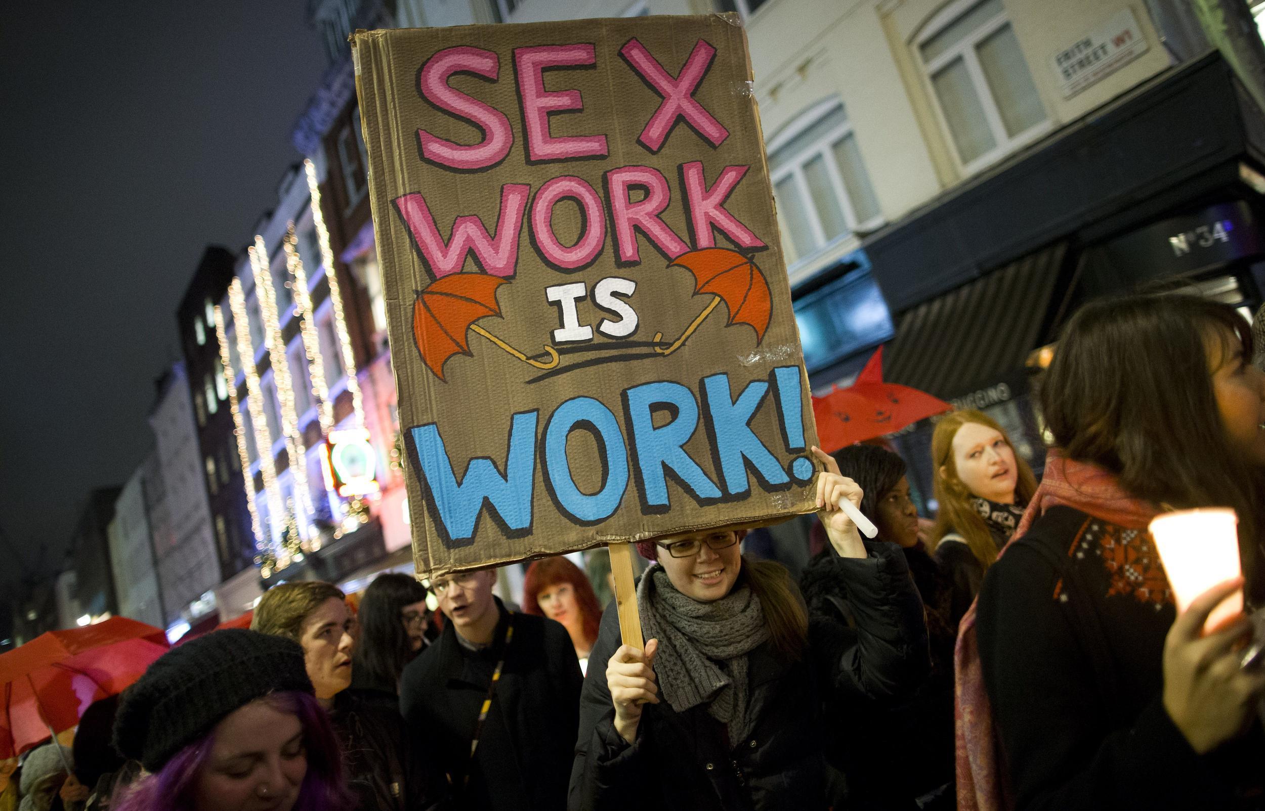 A protester holds a placard while marching through London after a candle-lit vigil to mark the international day to end violence against sex workers